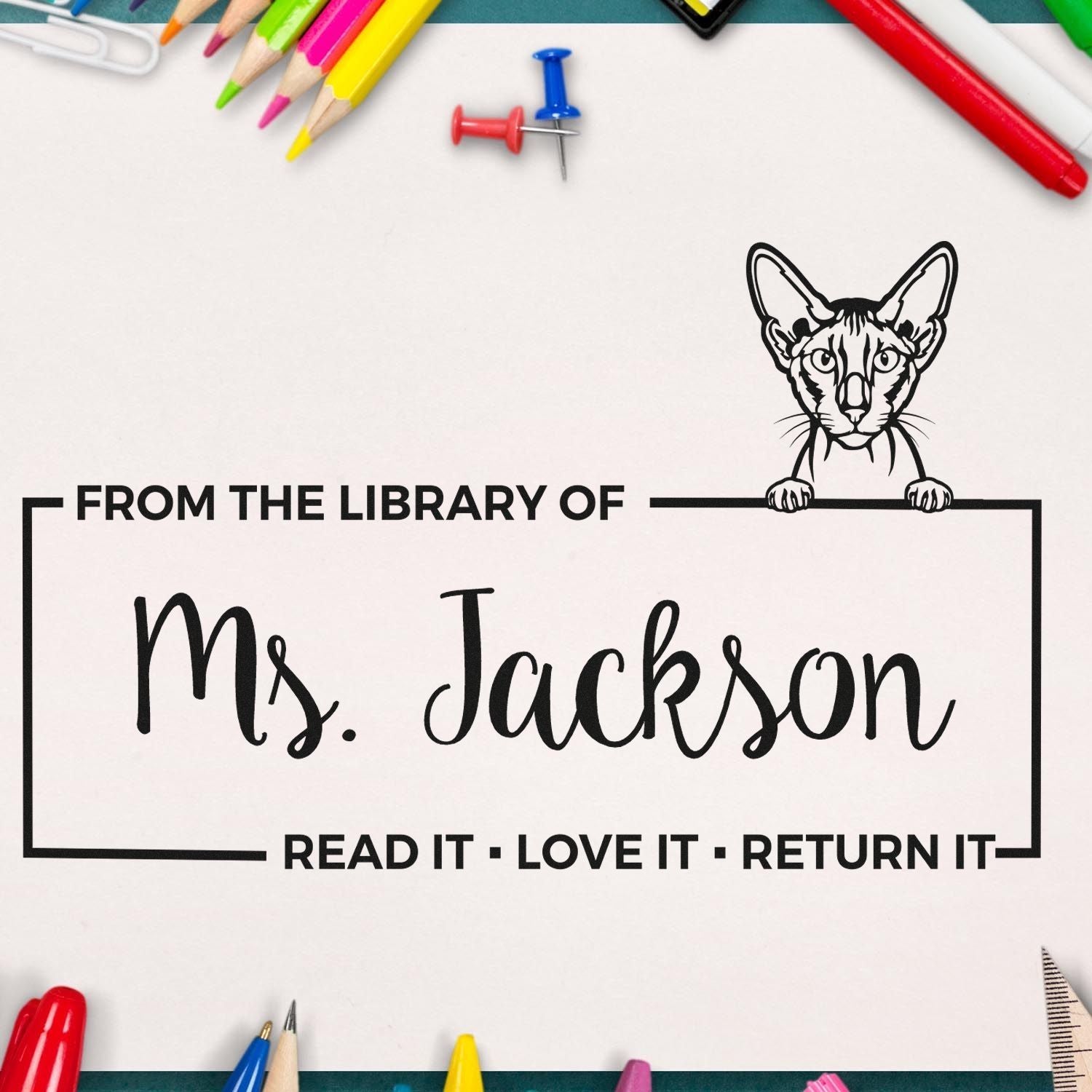 Personalized library book rubber stamp with cat design, From the Library of Ms. Jackson and return-it message.