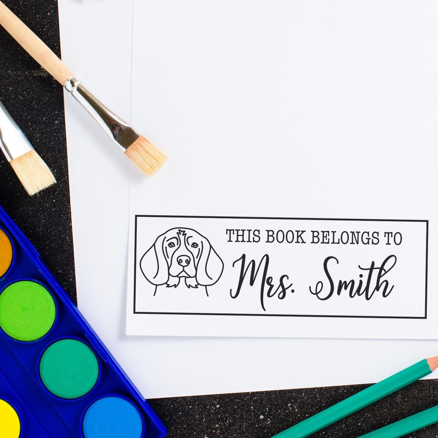 Personalized book stamp with dog illustration, custom rubber stamp reading This Book Belongs to Mrs. Smith.