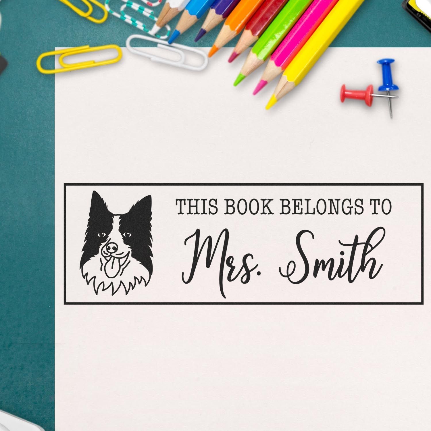 Custom rubber stamp with dog illustration and This Book Belongs to Mrs. Smith for personalized book labeling.