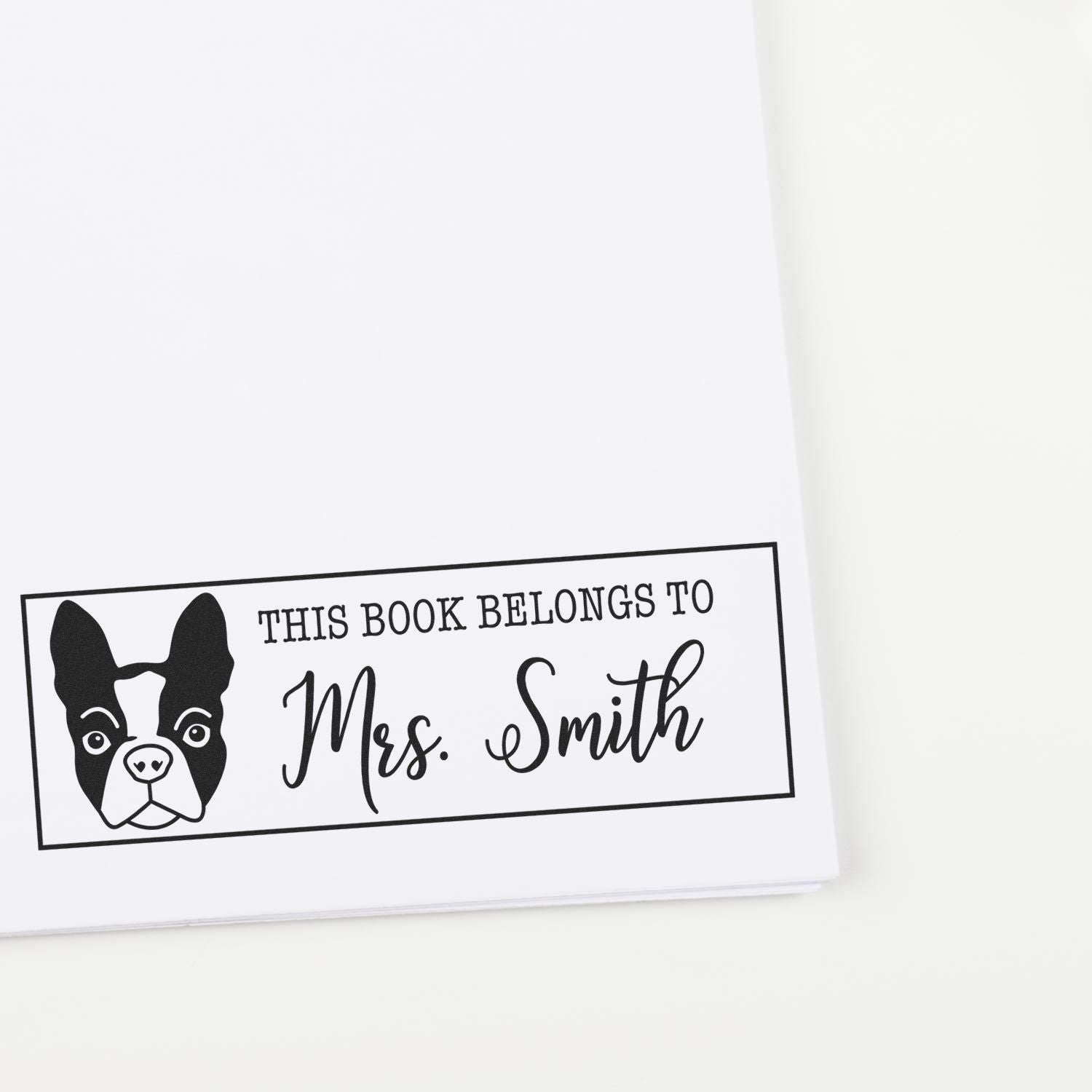 Personalized rubber book stamp with dog illustration and This Book Belongs to Mrs. Smith for labeling library books.