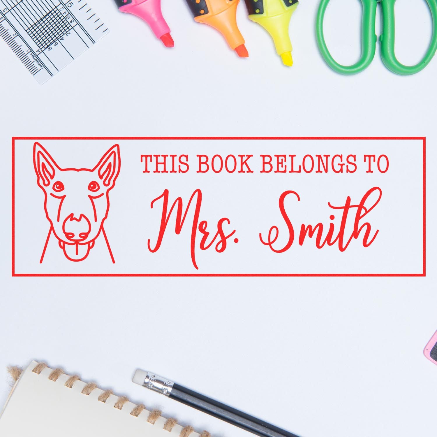 Personalized dog book rubber stamp reading This Book Belongs to Mrs. Smith for labeling library books.
