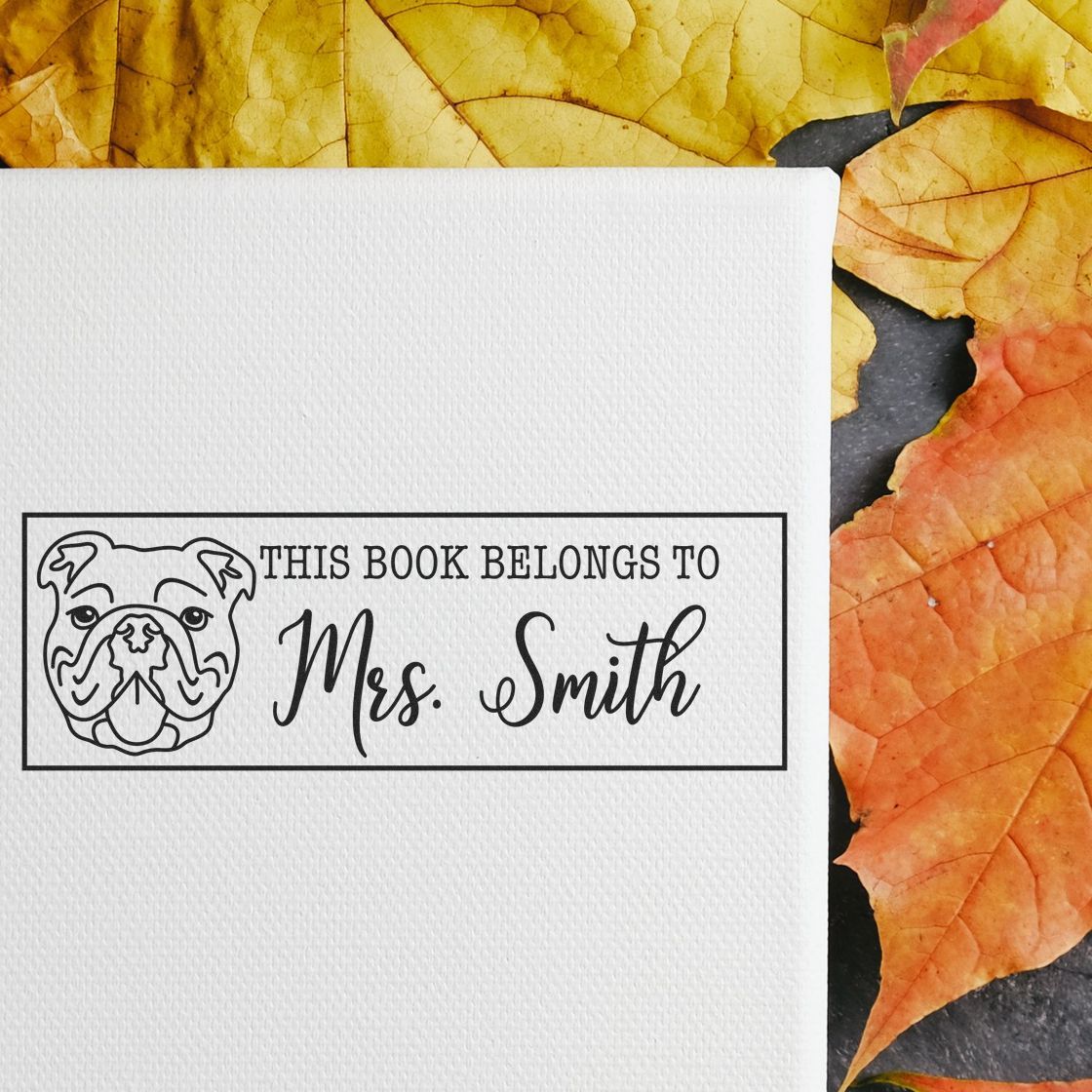 Custom rubber bookplate stamp with bulldog design and This Book Belongs to Mrs. Smith for personalized library labeling.
