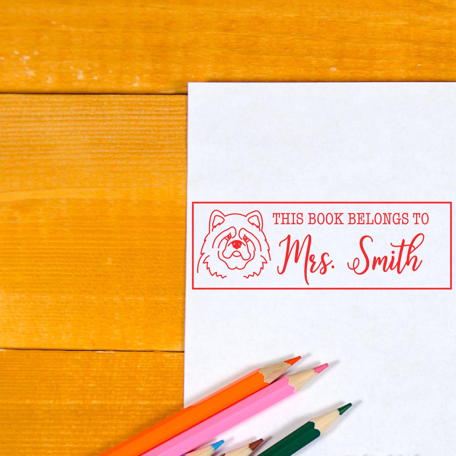 Personalized rubber book stamp with dog design and This Book Belongs to Mrs. Smith for custom library books.