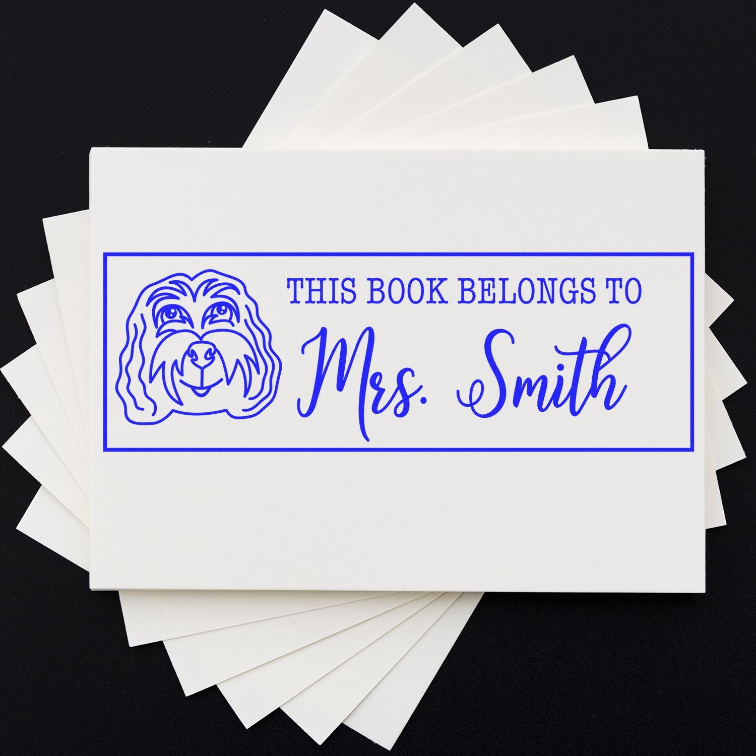 Personalized rubber book stamp with dog illustration and This Book Belongs To Mrs. Smith for custom library books.