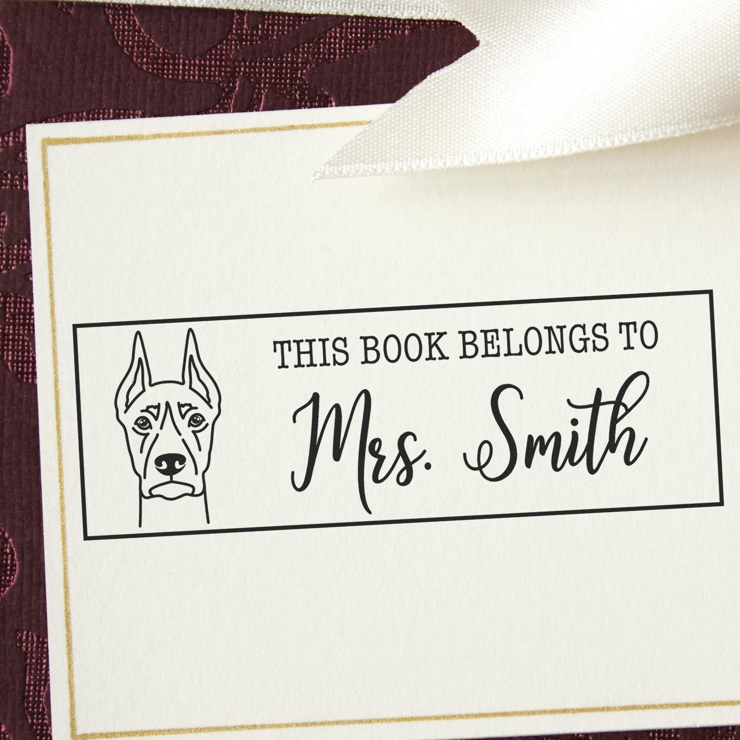 Personalized dog rubber stamp bookplate reading This Book Belongs to Mrs. Smith for labeling library books.