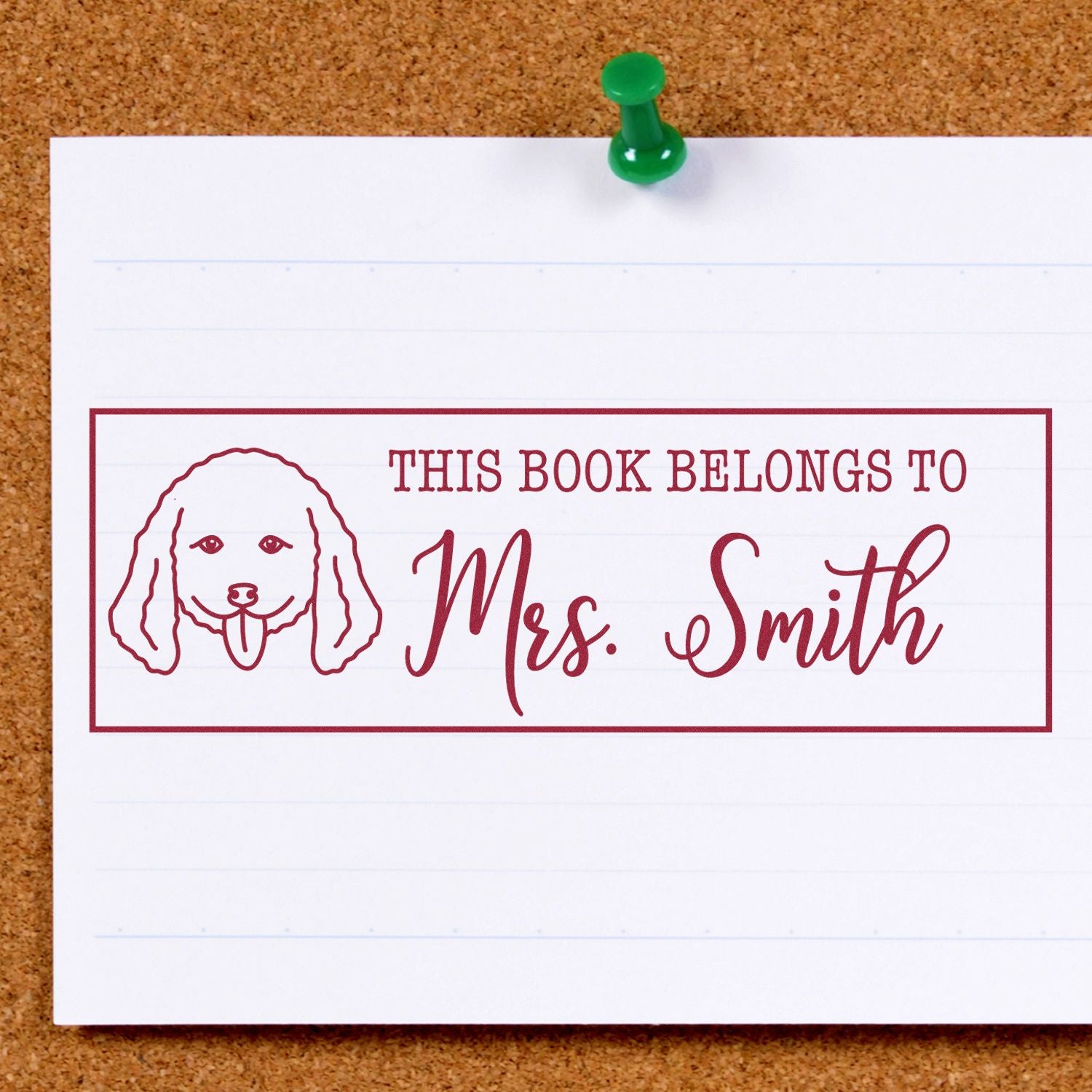 Custom book stamp with dog design reading This Book Belongs to Mrs. Smith on a pinned paper card.