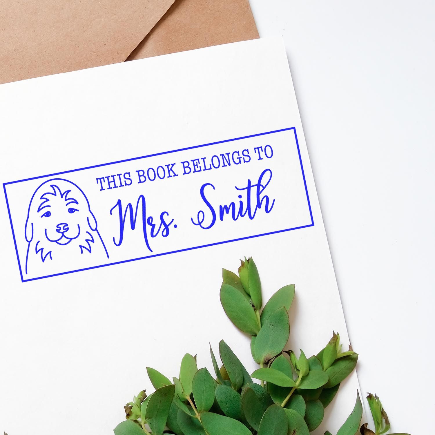 Personalized rubber book stamp with dog design and This Book Belongs to Mrs. Smith text for custom library books.