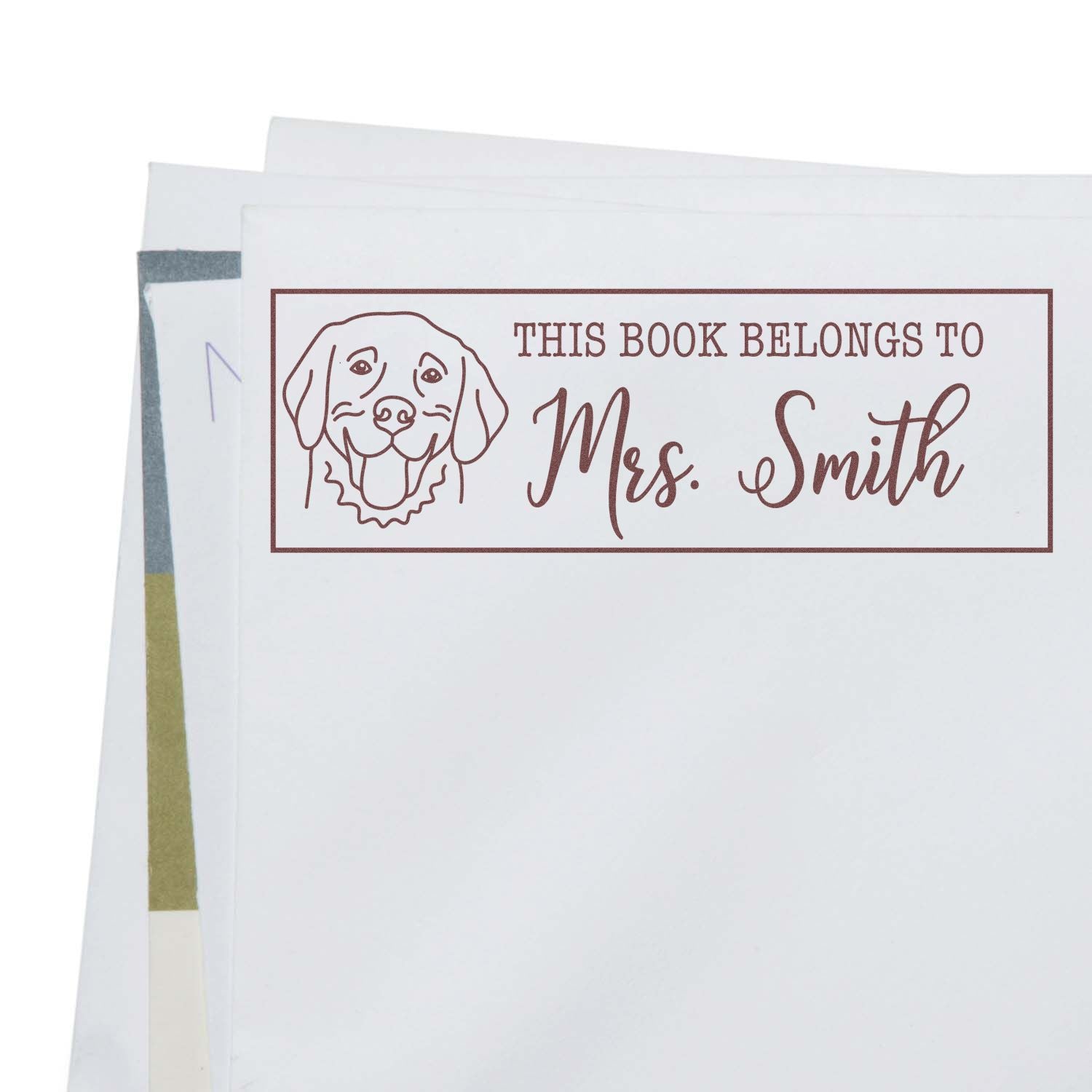 Personalized rubber book stamp with dog illustration and This Book Belongs to Mrs. Smith custom ex libris design.