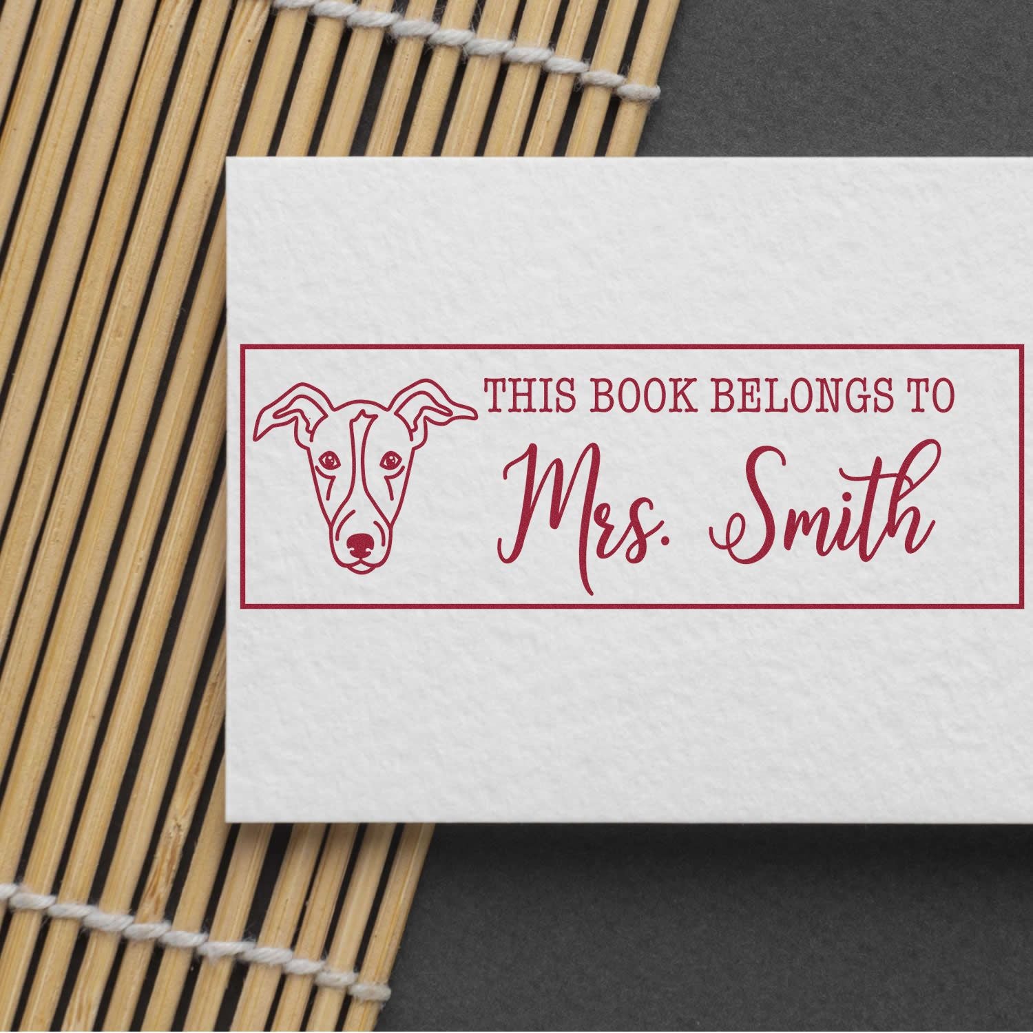 Custom dog book plate rubber stamp with This Book Belongs to Mrs. Smith on white paper.