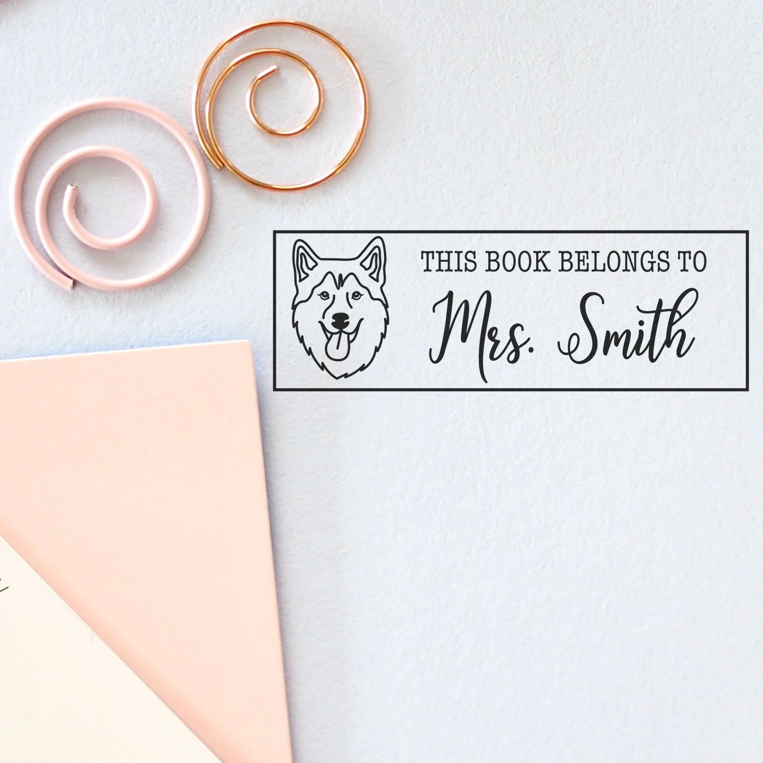 Custom dog rubber stamp reading This book belongs to Mrs. Smith for personalized library books and stationery.