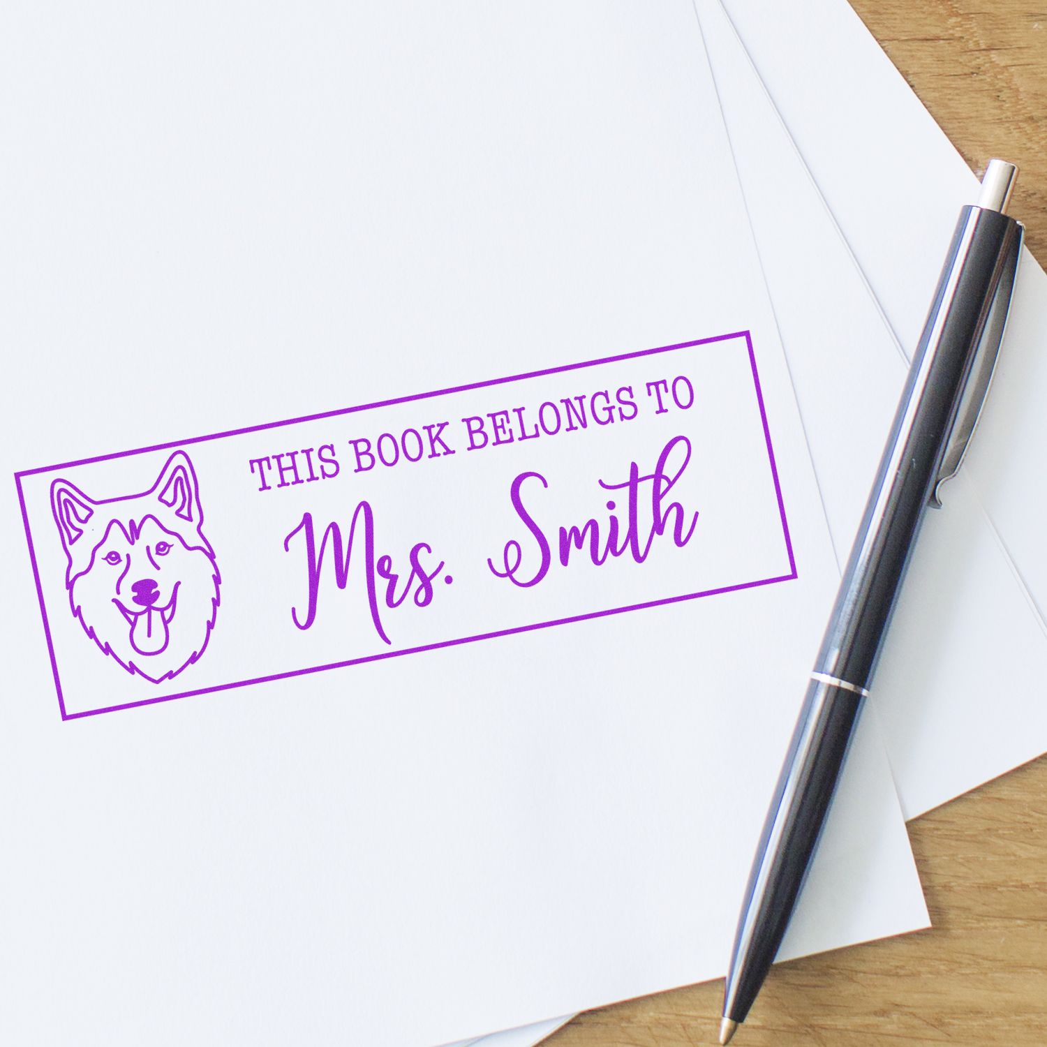 Personalized rubber book stamp for Mrs. Smith with husky design, marking books with a custom This Book Belongs To label.
