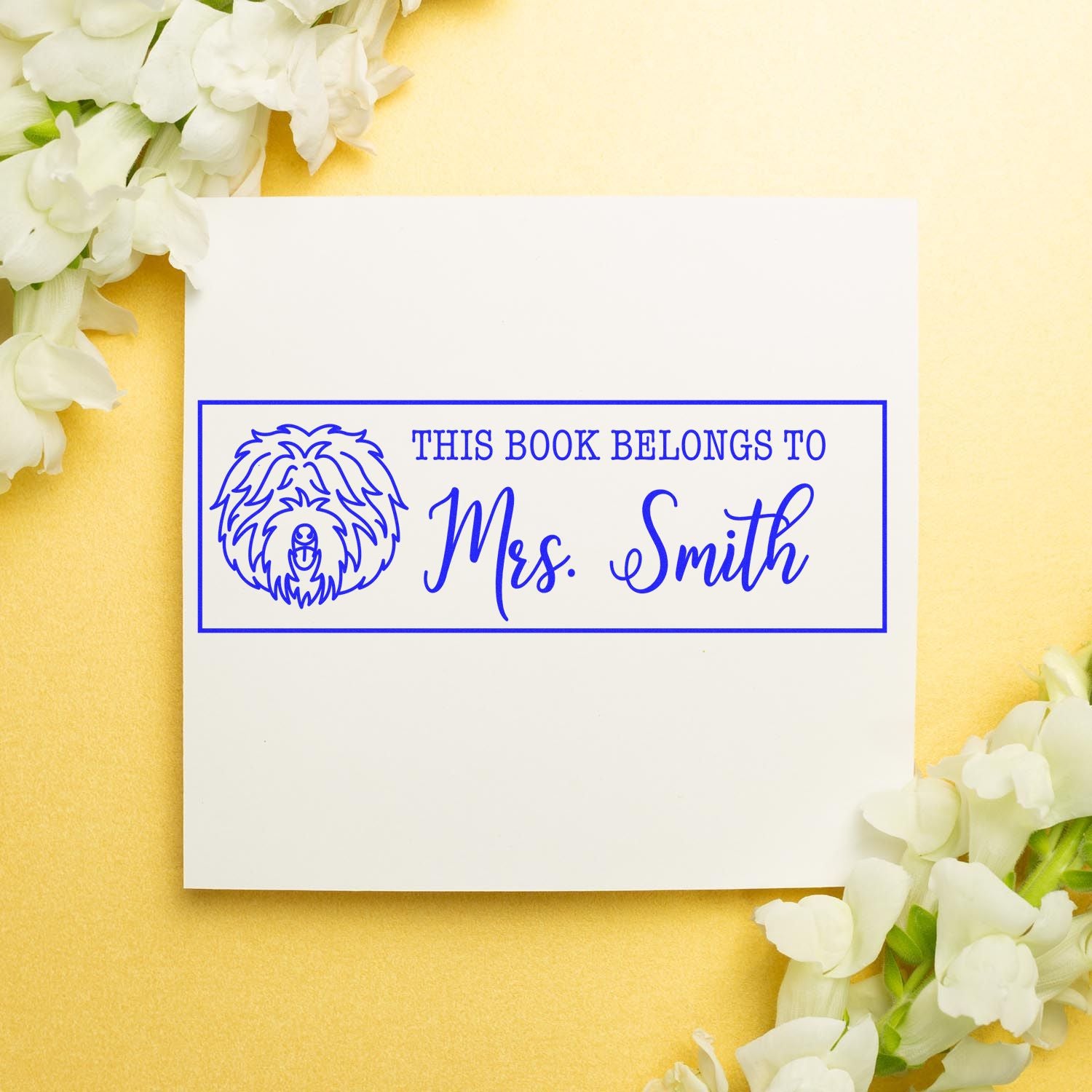 Personalized book belongs to rubber stamp with dog design and Mrs. Smith name for custom library books.