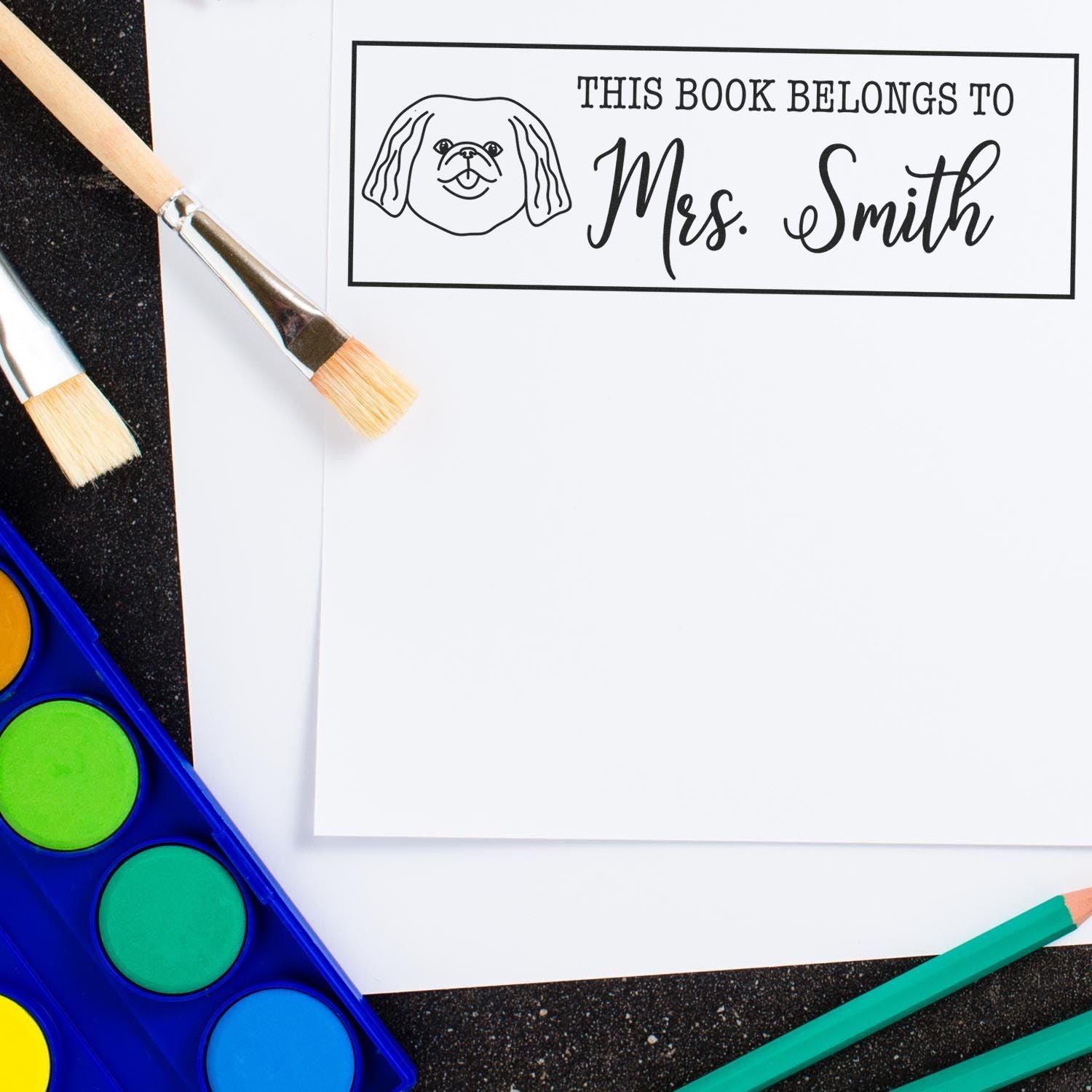 Custom rubber stamp bookplate with dog illustration and This Book Belongs to Mrs. Smith for personalized library books.