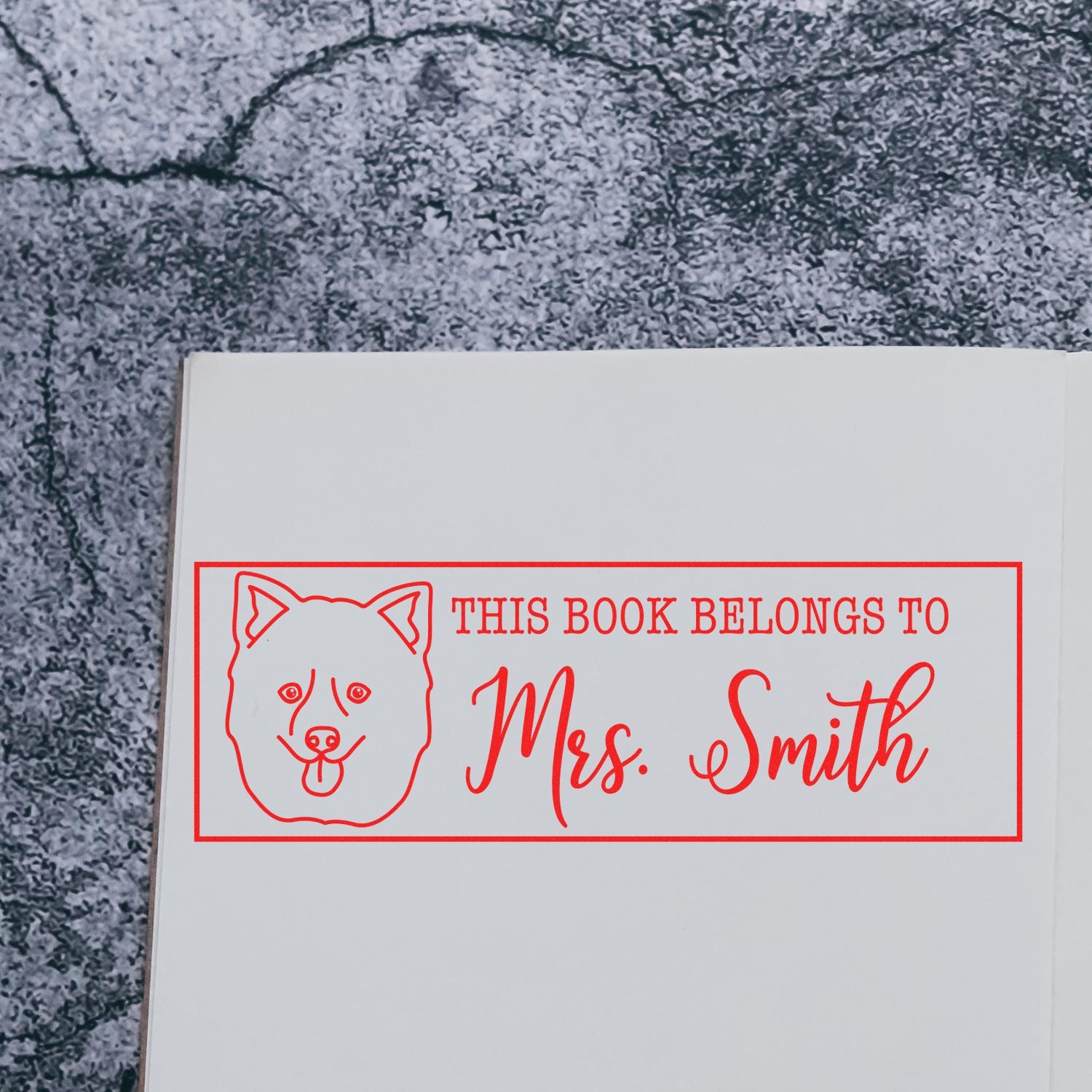 Personalized custom rubber stamp for books featuring dog icon and This Book Belongs to Mrs. Smith name imprint.