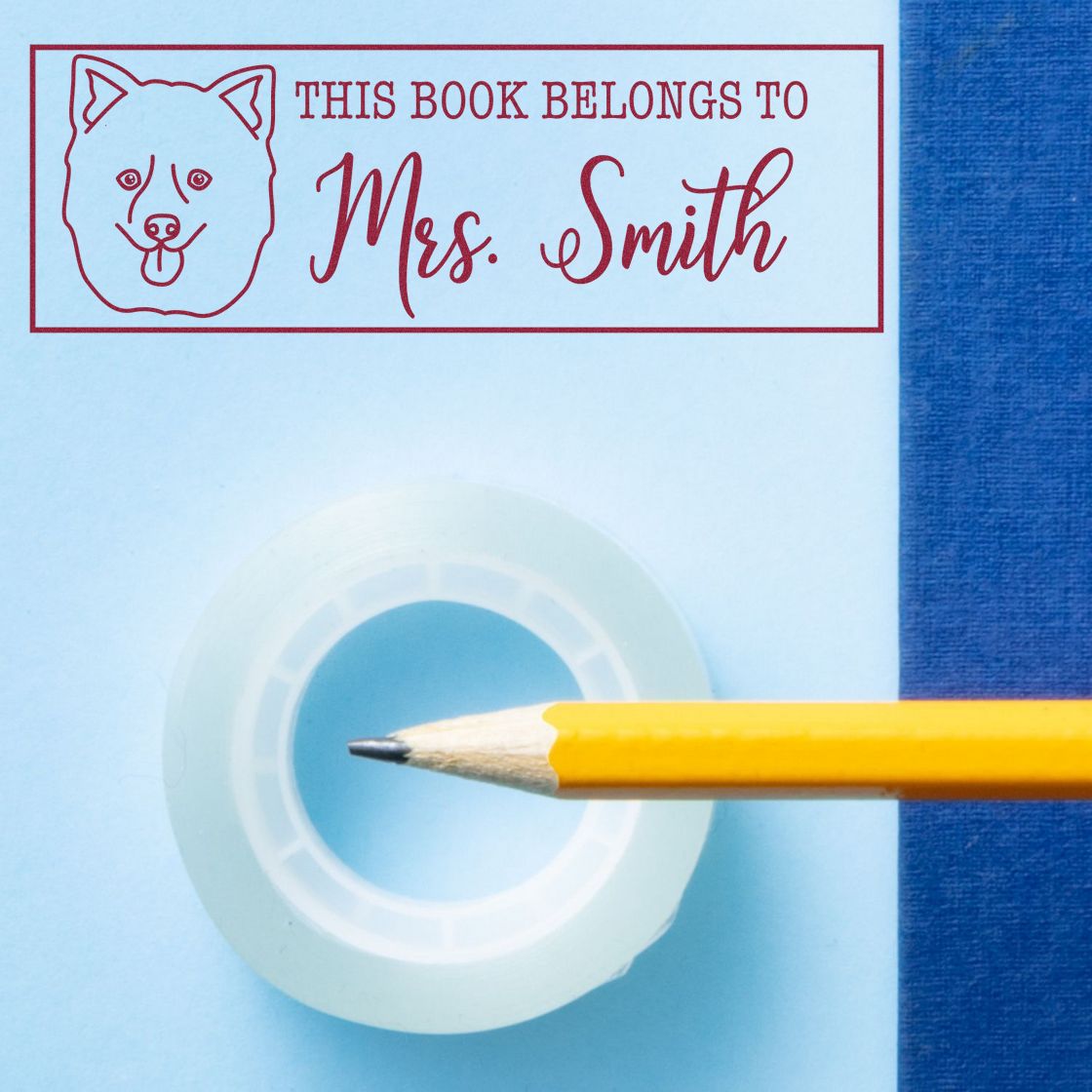 Personalized rubber book stamp with dog icon and This Book Belongs to Mrs. Smith text for custom library marking.