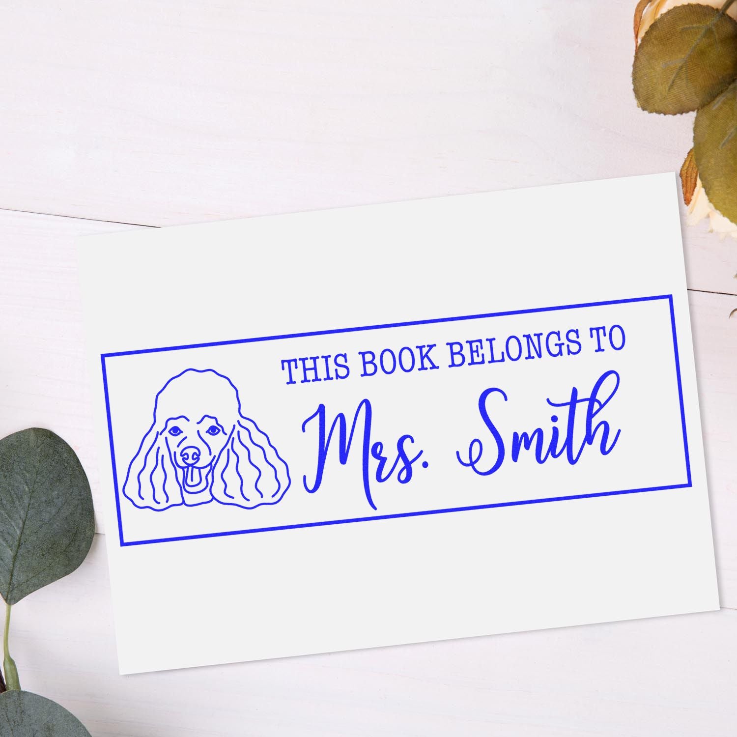 Personalized rubber stamp for books with poodle illustration and This Book Belongs to Mrs. Smith text.