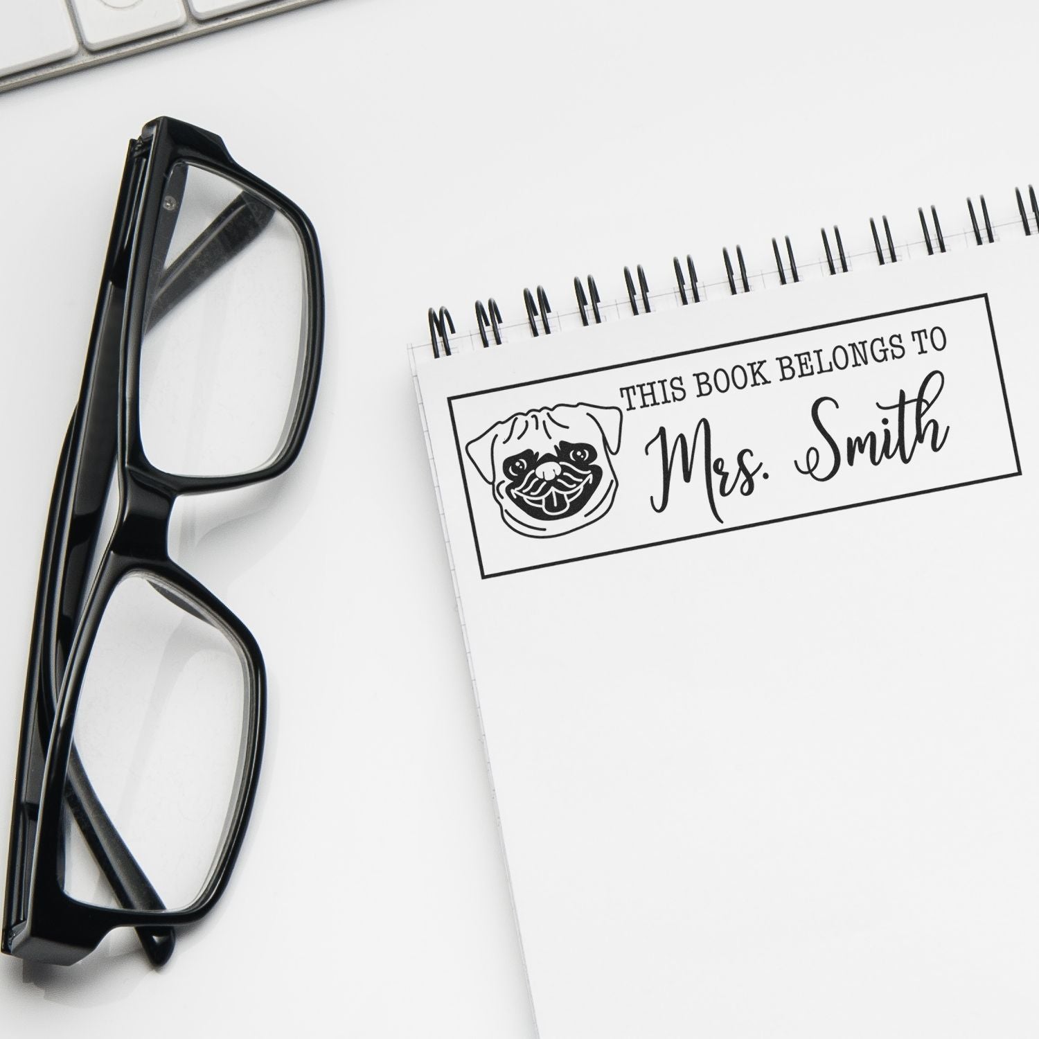 Custom book rubber stamp for personal libraries, reading This Book Belongs to Mrs. Smith with pug icon.