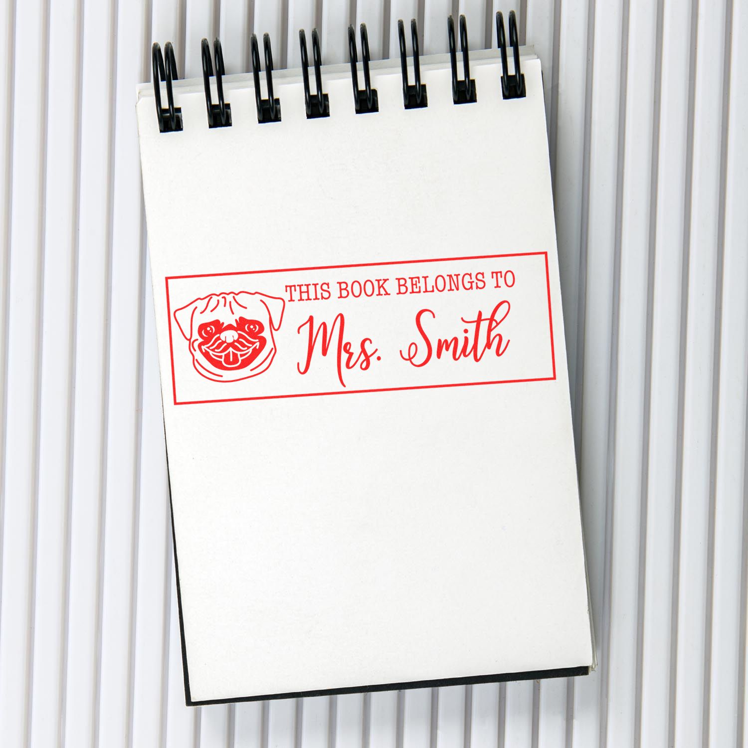 Custom rubber stamp for books with pug design, reading This Book Belongs to Mrs. Smith for personalized book ownership.