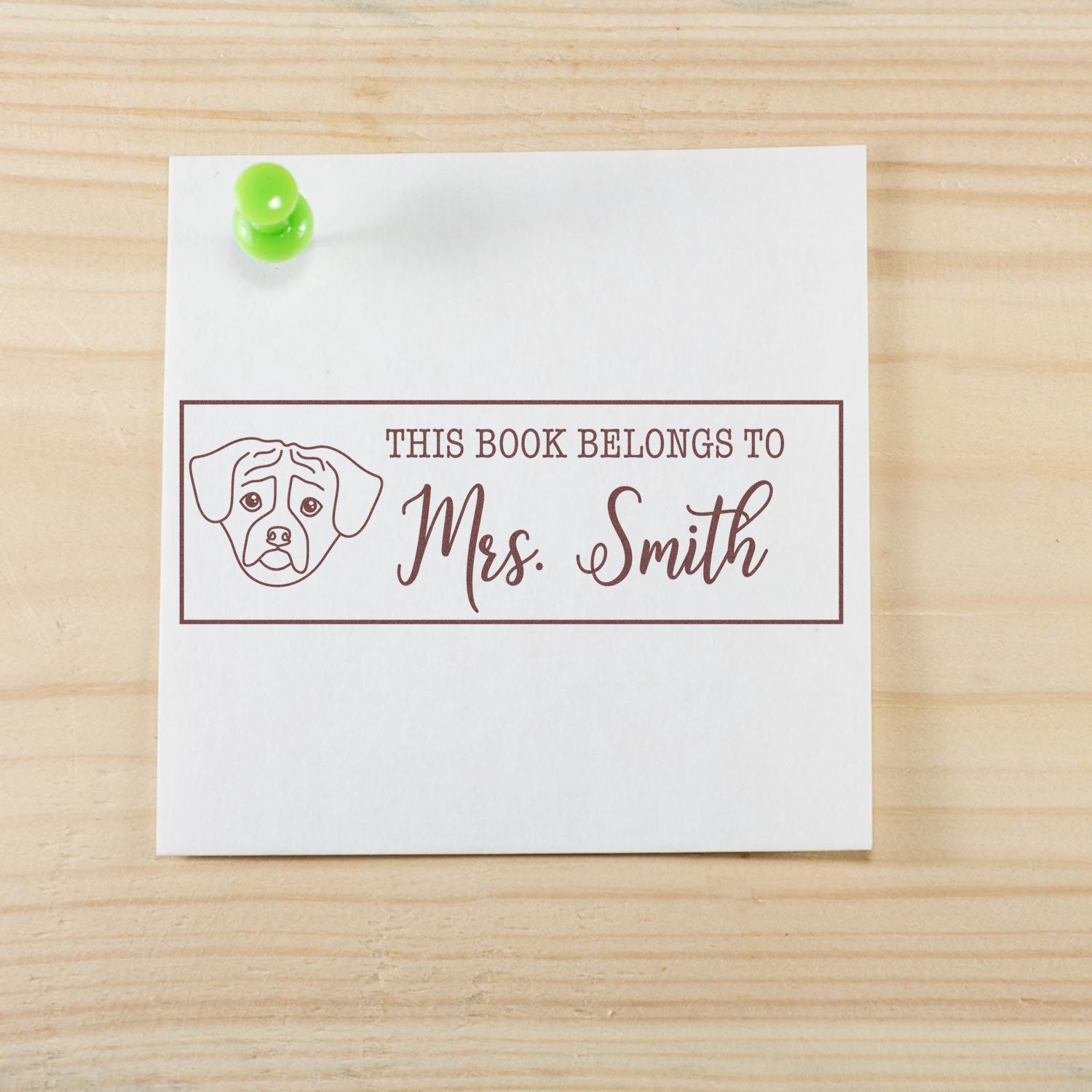 Custom rubber stamp bookplate with dog illustration and This Book Belongs to Mrs. Smith for personalized library labeling.