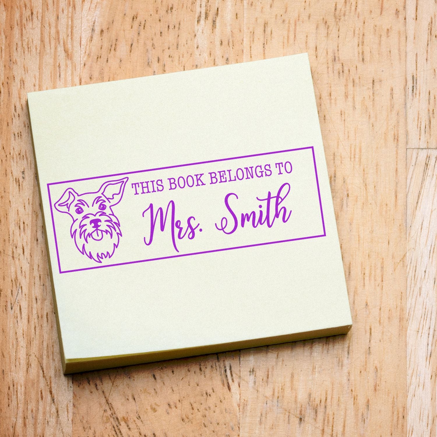Personalized rubber book stamp with dog illustration and This Book Belongs to Mrs. Smith library ownership label.