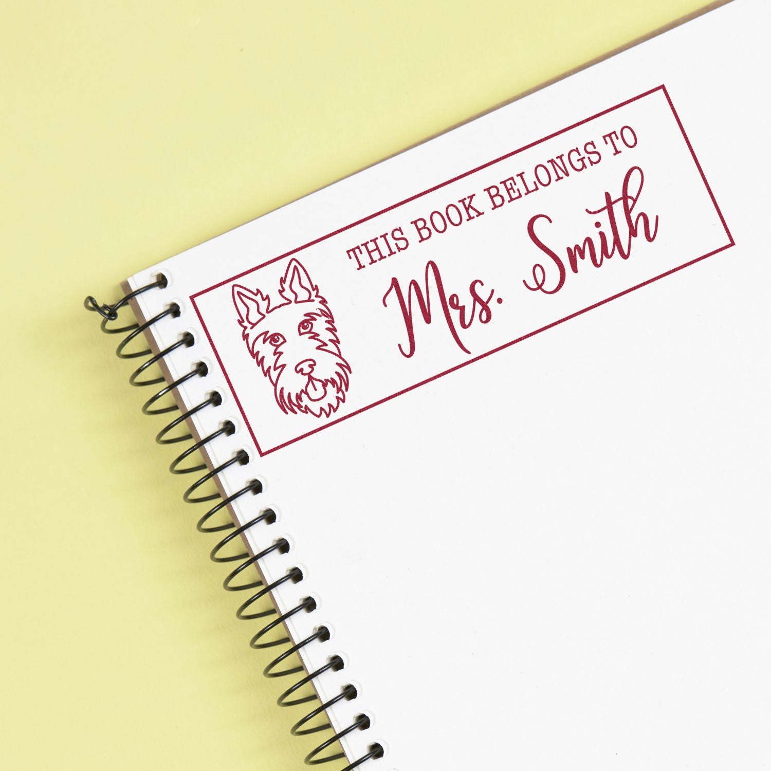 Custom rubber book stamp reading This Book Belongs to Mrs. Smith with dog icon for personalized library labels.