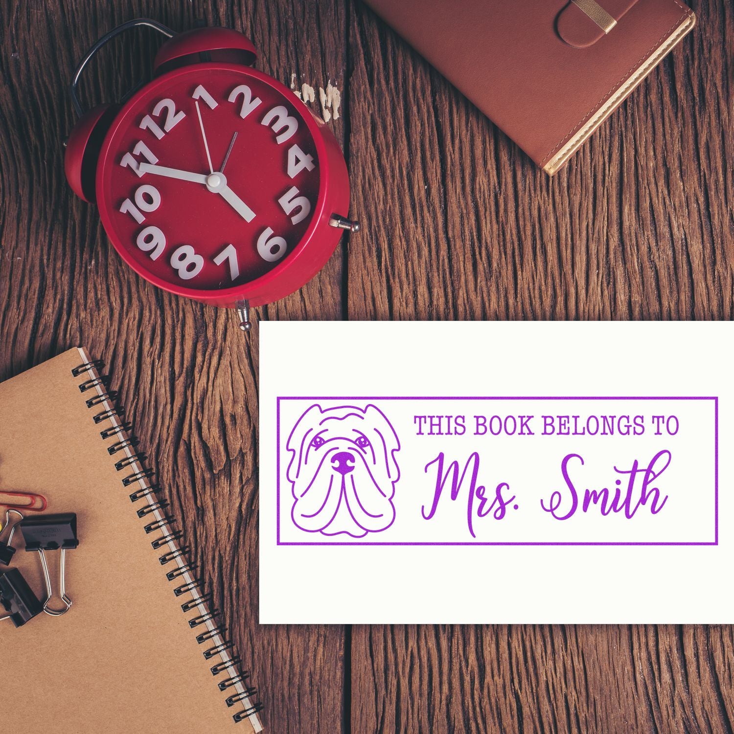 Custom rubber book stamp with dog design and This Book Belongs to Mrs. Smith for personalized library labeling.