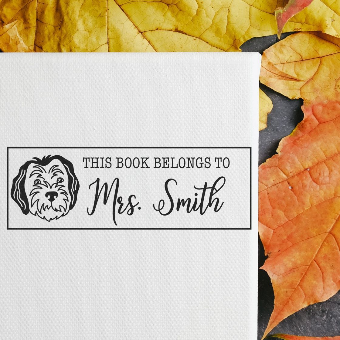 Personalized dog book stamp reading This Book Belongs to Mrs. Smith for custom library labeling and book ownership marking.