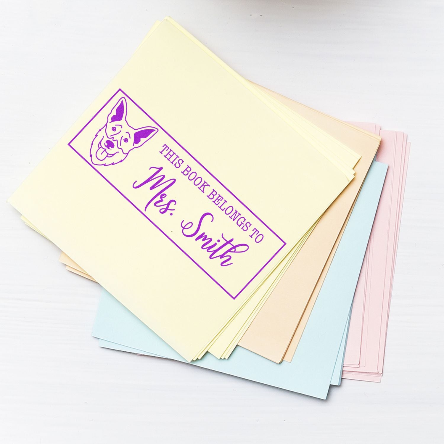Custom rubber stamp for personalized book labels, showing a dog bookplate design with This Book Belongs to Mrs. Smith.