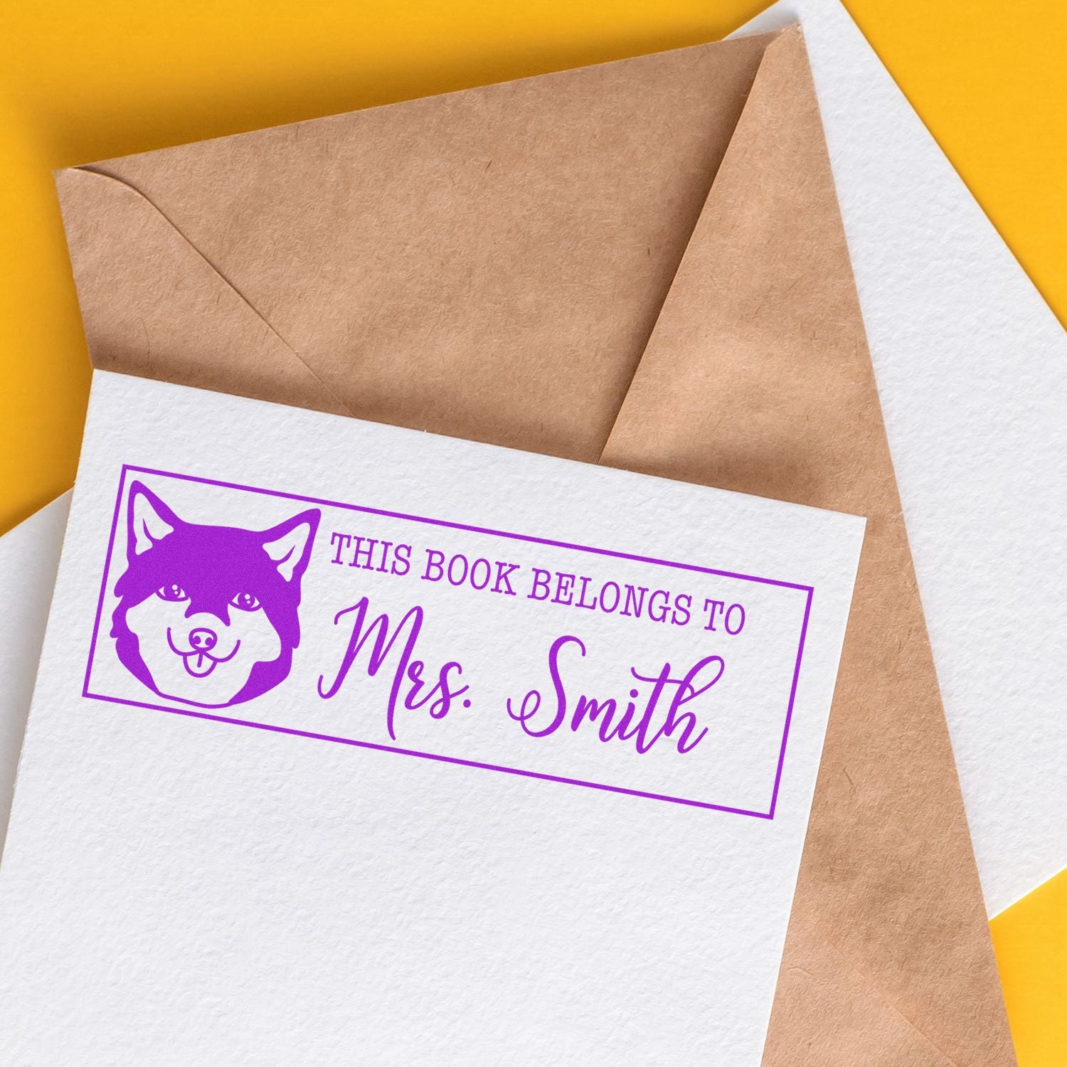 Custom purple dog rubber stamp reading "This Book Belongs to Mrs. Smith" for personal library labeling.