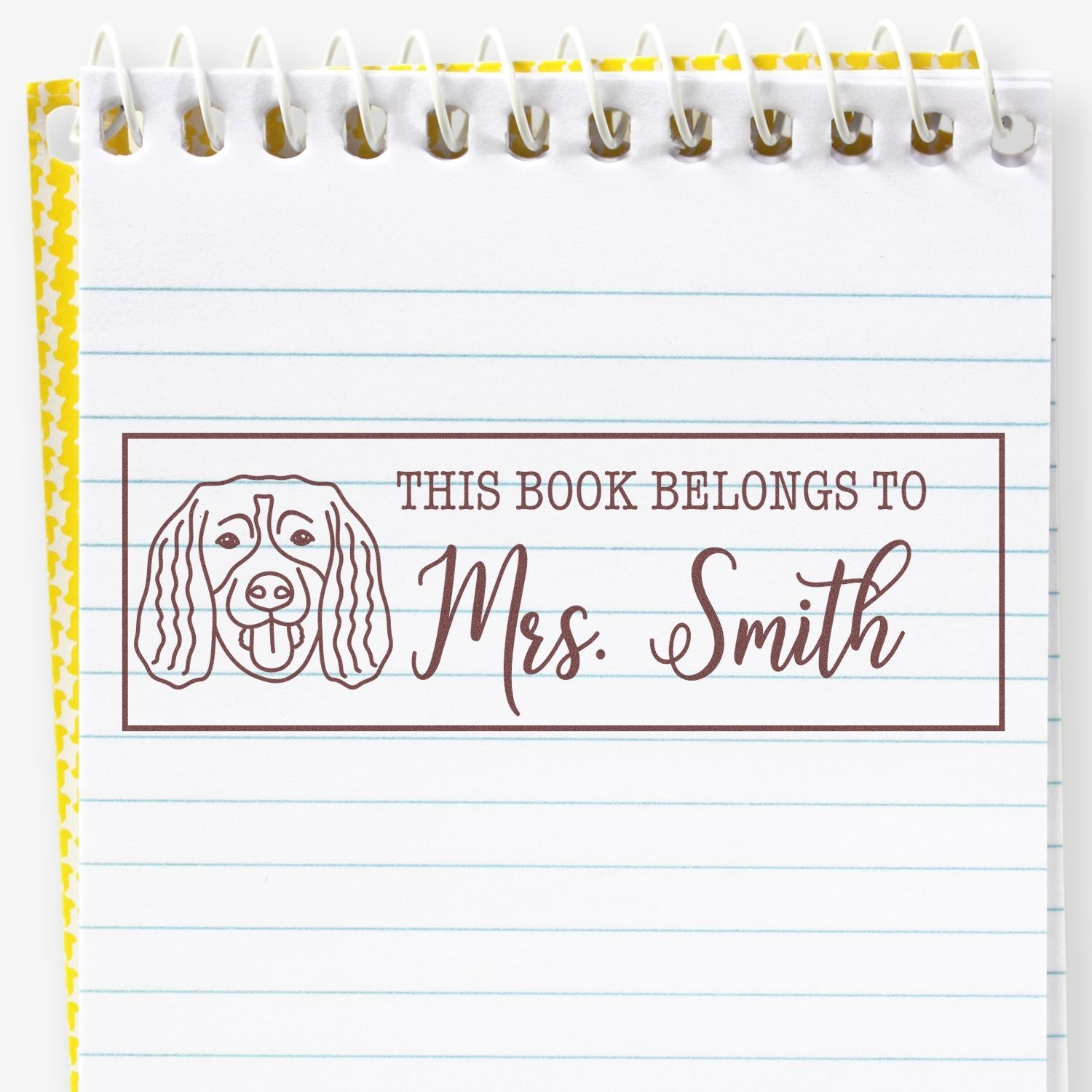 Personalized rubber book stamp with dog illustration and This Book Belongs to Mrs. Smith for marking library books.