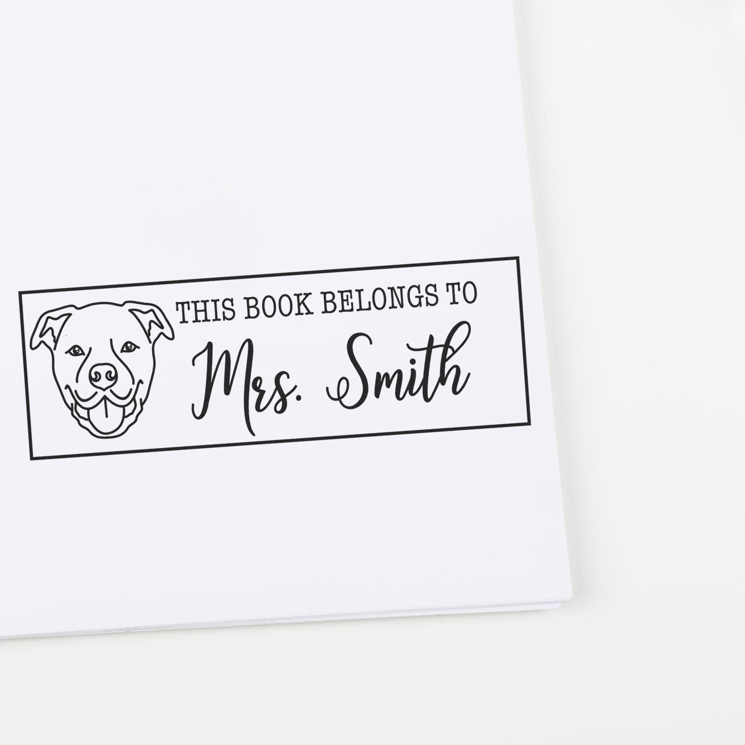 Personalized book belongs to rubber stamp with dog design and Mrs. Smith name for custom library and classroom use.