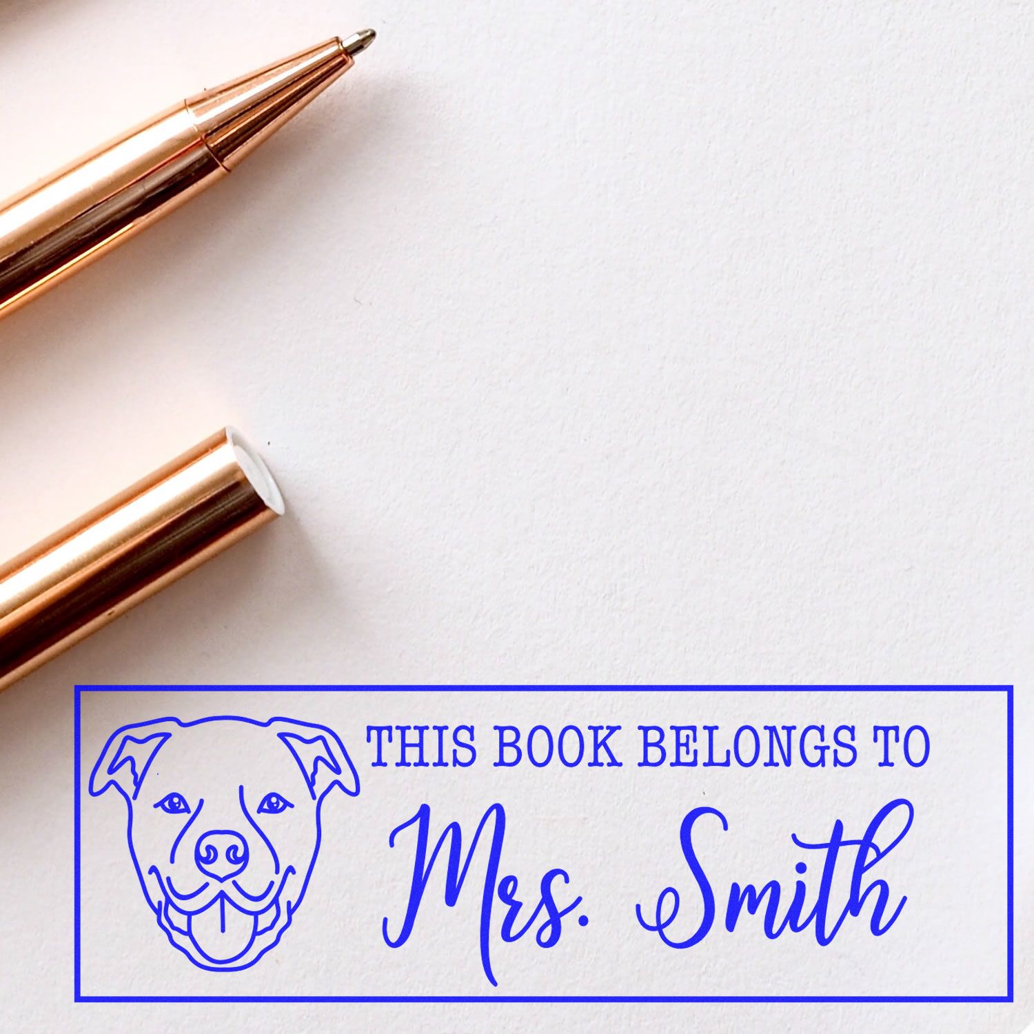 Custom rubber stamp imprint reading This Book Belongs to Mrs. Smith with dog icon for personal book labeling.