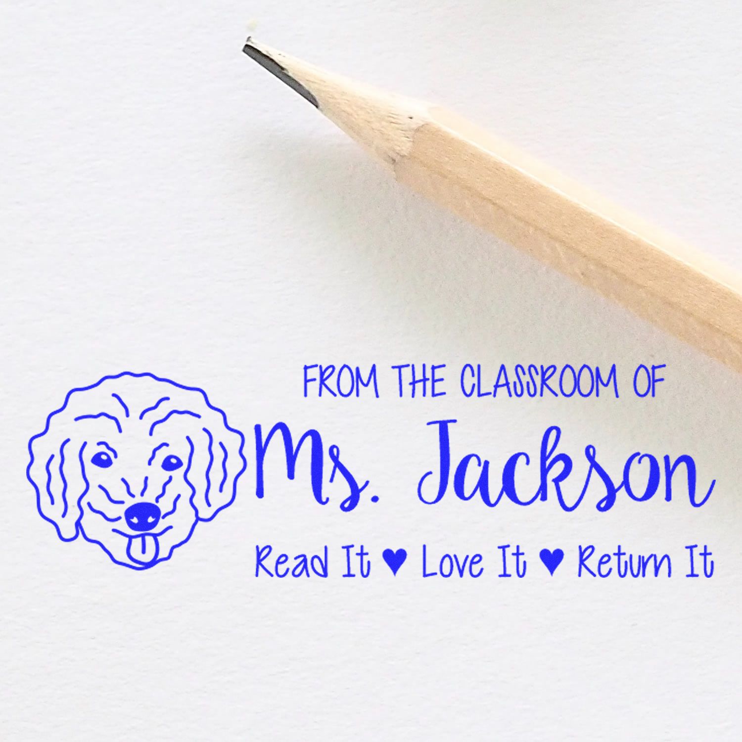 Custom classroom rubber stamp with dog design and Read It, Love It, Return It message for Ms. Jacksons books.
