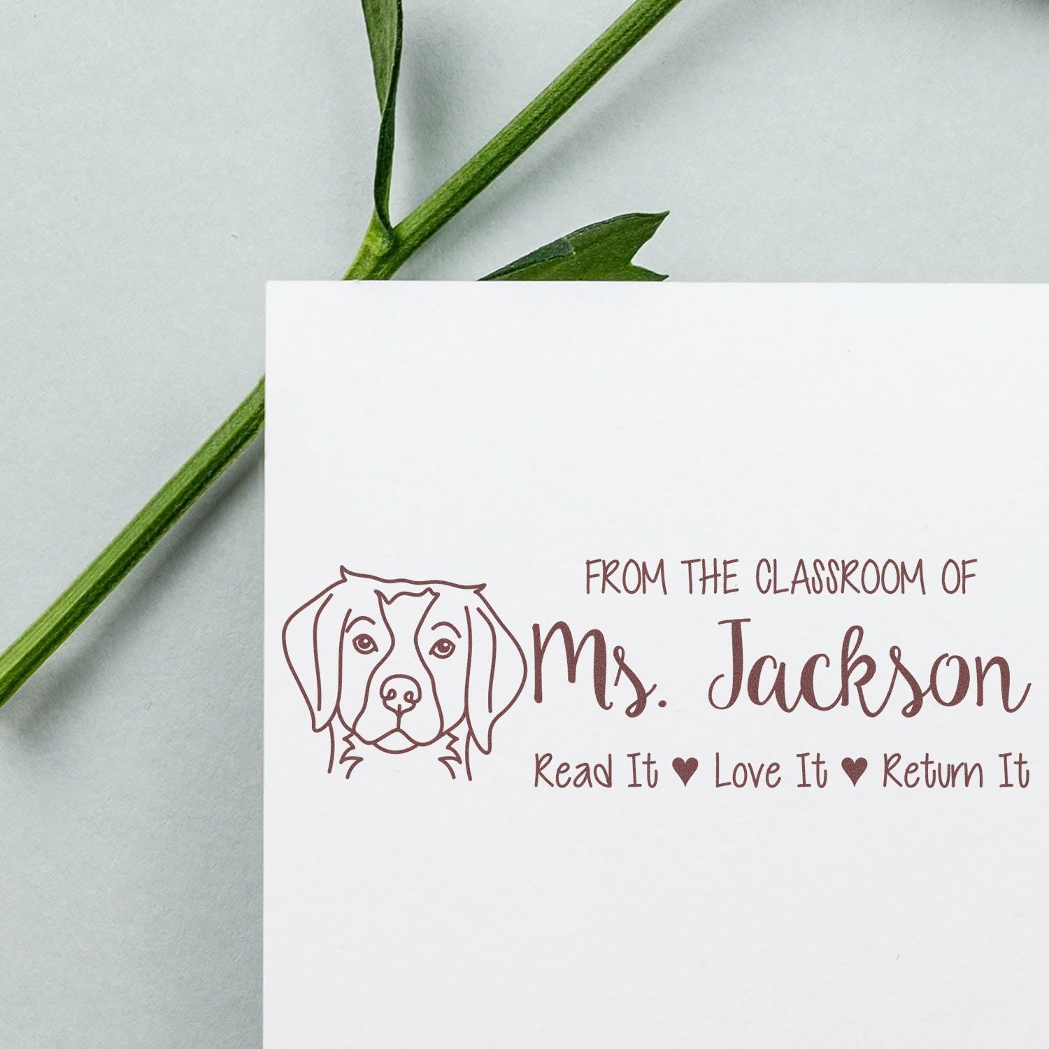 Custom teacher rubber stamp for classroom books, featuring dog design and Read It Love It Return It from Mrs. Jackson.