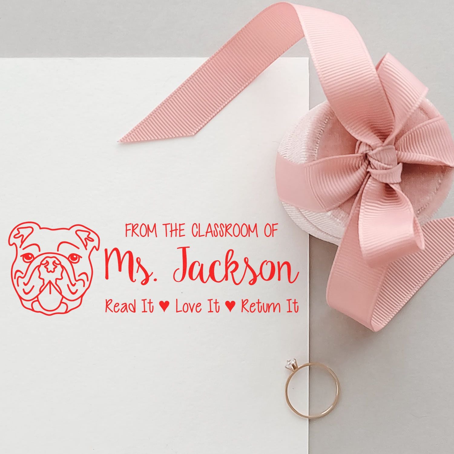 Personalized teacher rubber stamp for Ms. Jackson with bulldog logo and "Read It, Love It, Return It" book mark.