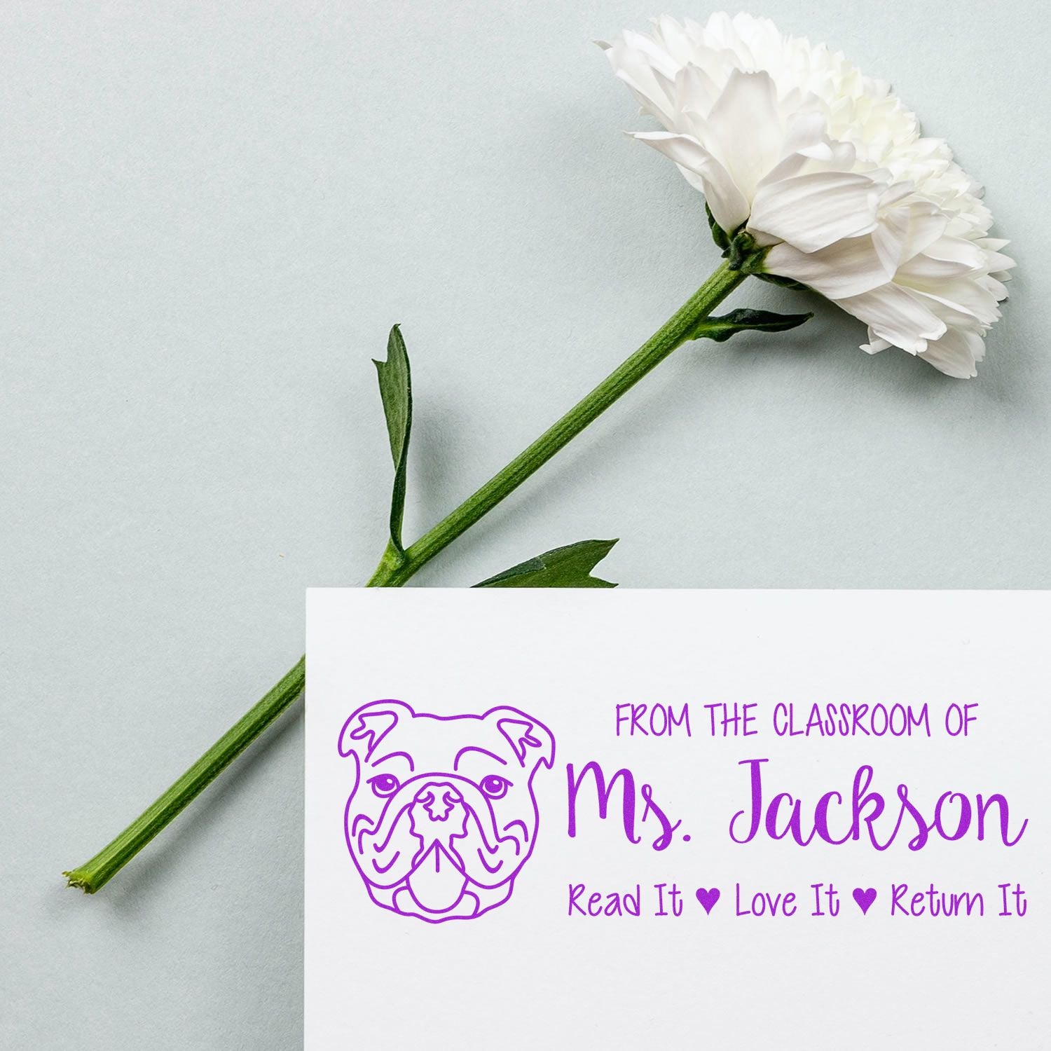 Personalized purple rubber stamp for teacher Ms. Jackson with bulldog logo and Read It, Love It, Return It classroom message.