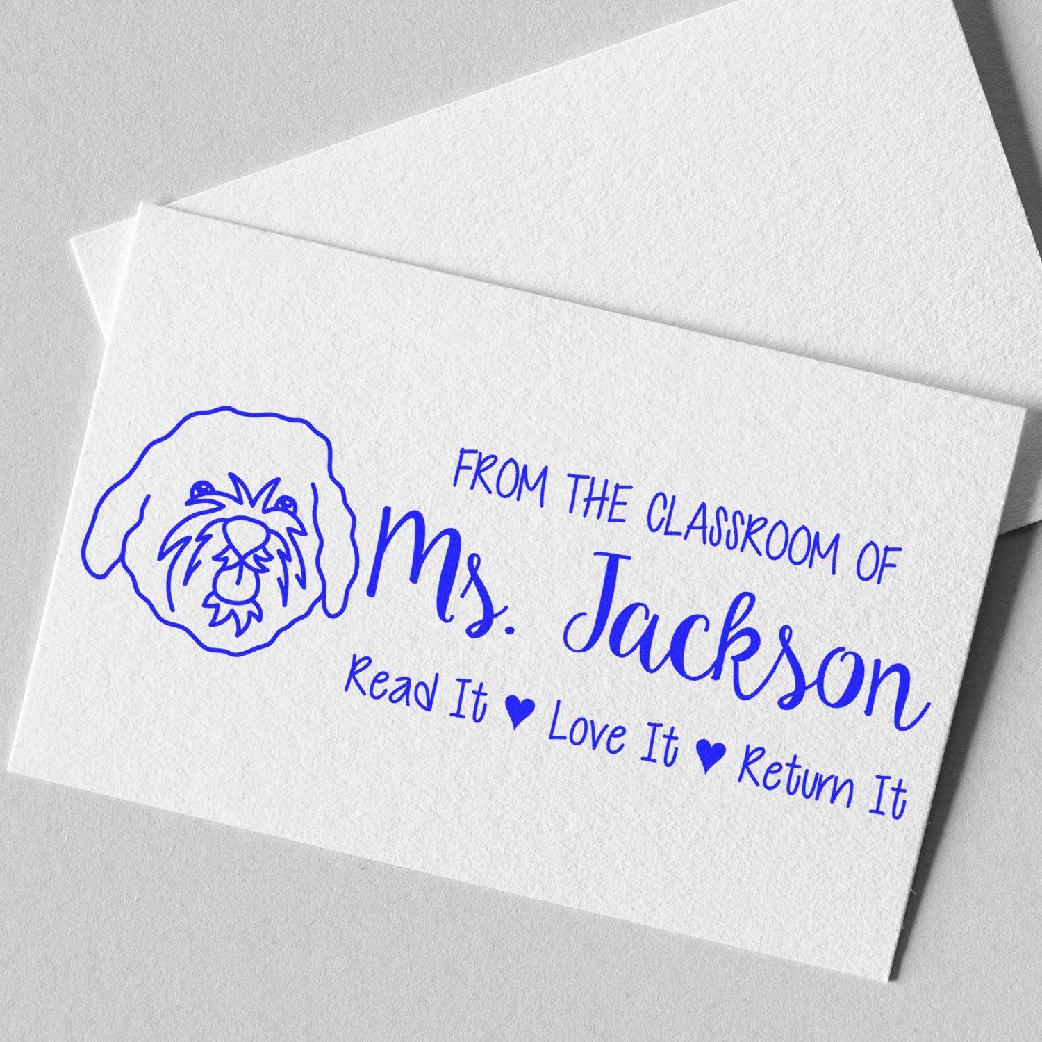 Custom teacher rubber stamp with dog icon and classroom message: From the Classroom of Ms. Jackson, Read It, Love It, Return It.