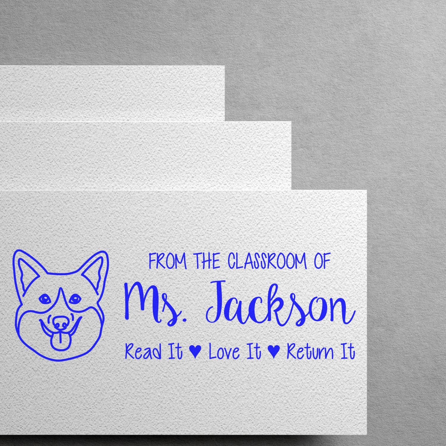 Custom classroom rubber stamp with dog icon, reading From the Classroom of Ms. JacksonRead It, Love It, Return It.