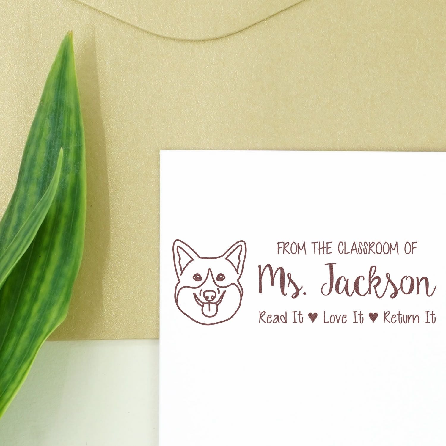 Personalized classroom rubber stamp with corgi logo, Ms. Jackson name, and Read It, Love It, Return It book label.