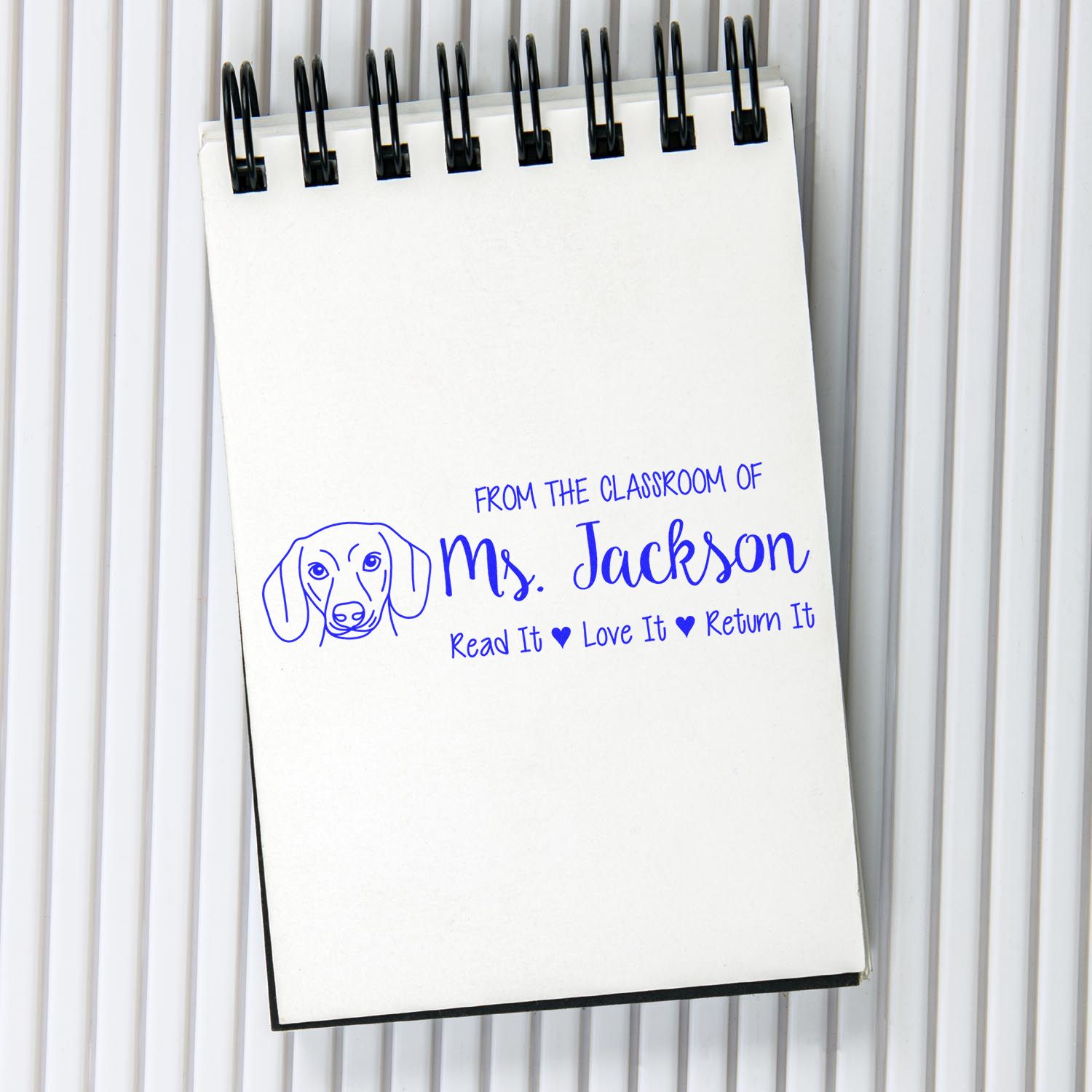 Custom classroom rubber stamp with dog logo and From the Classroom of Ms. Jackson, Read It, Love It, Return It text.