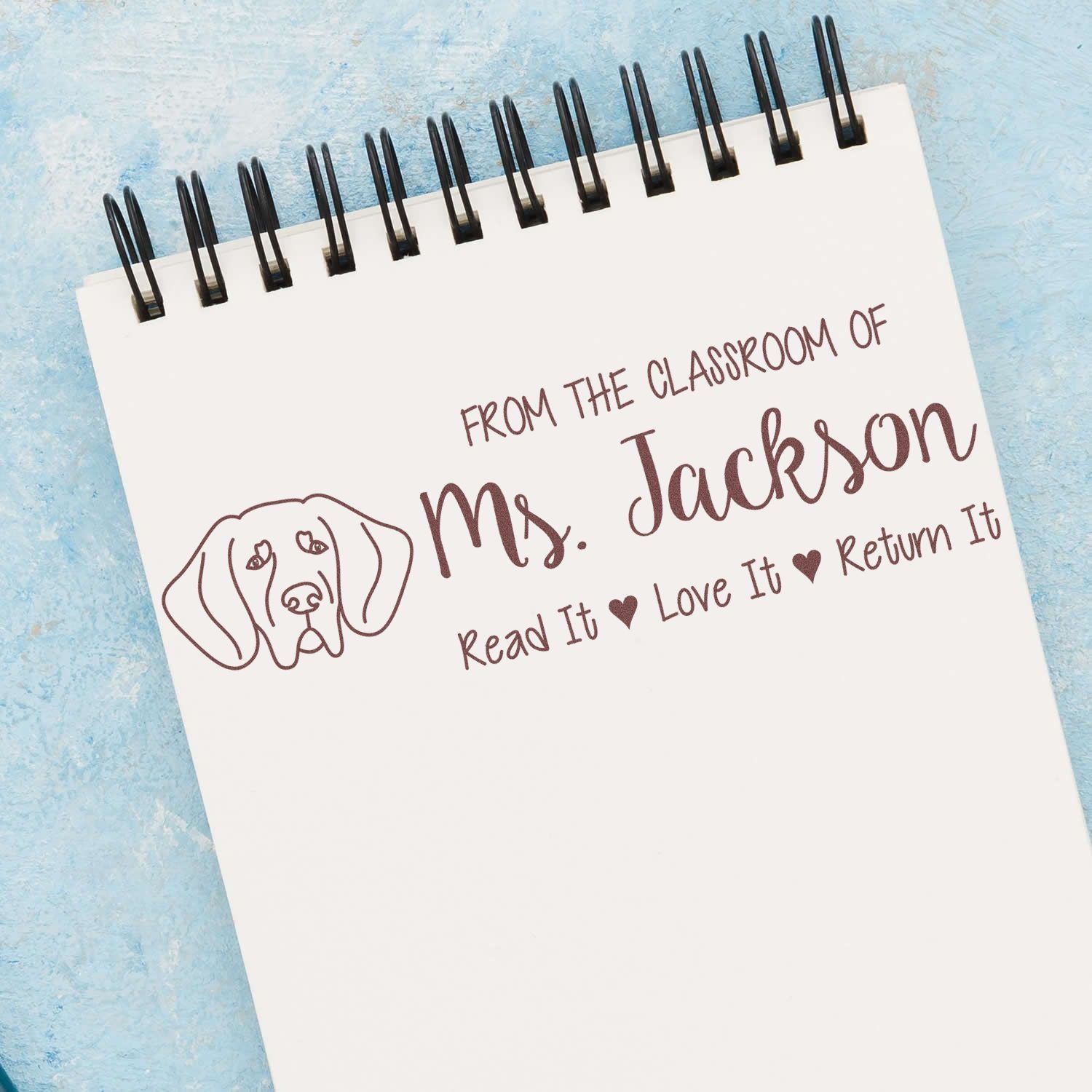 Personalized teacher rubber stamp design for Ms. Jackson, with dog icon and Read It, Love It, Return It classroom message.