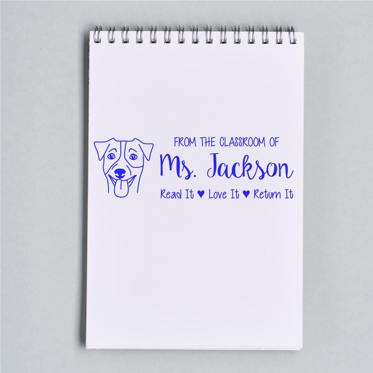 Custom classroom rubber stamp for books, featuring a dog icon and Read It, Love It, Return It message for Ms. Jackson.