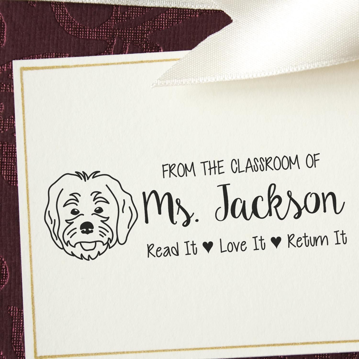Personalized rubber stamp for classroom books with dog icon and Read It, Love It, Return It for Ms. Jackson.