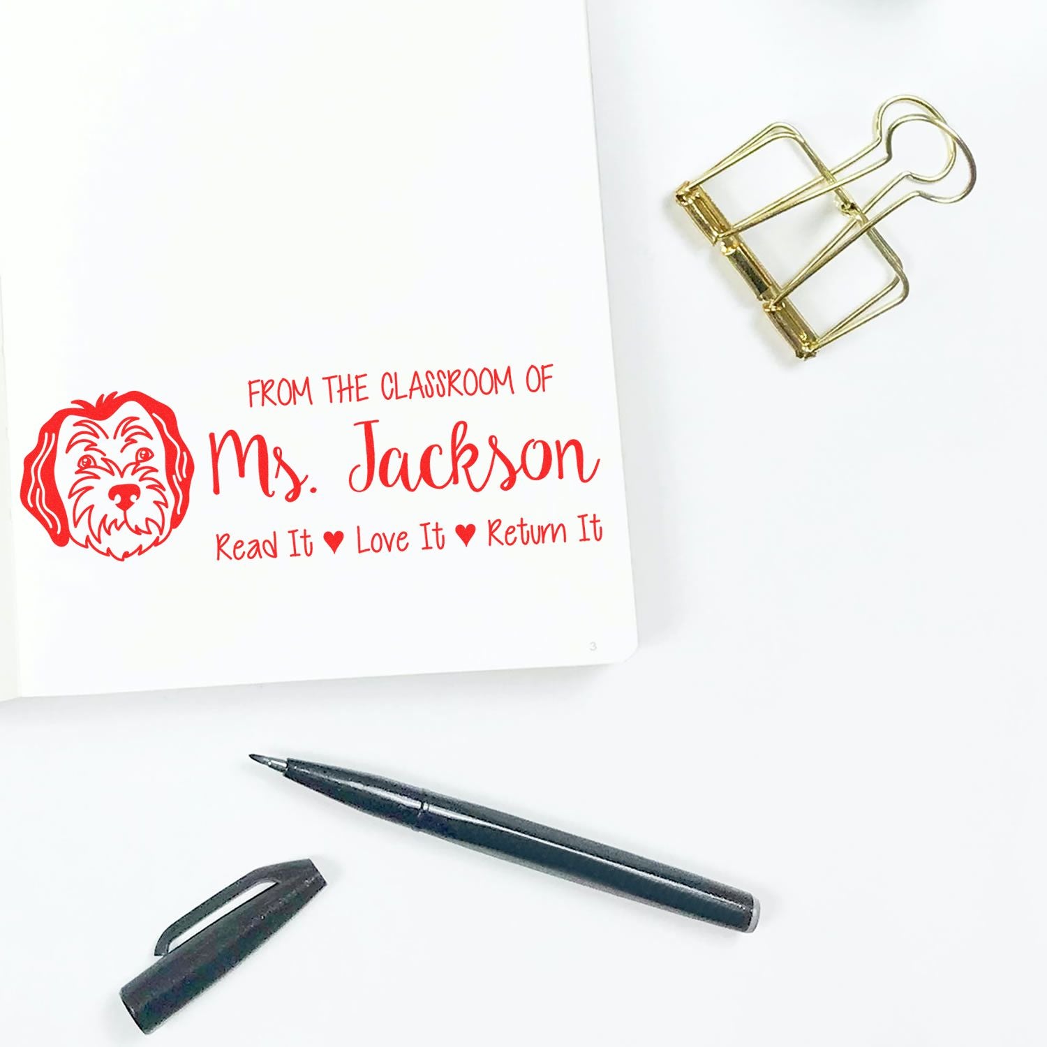 Custom classroom rubber stamp for Ms. Jackson, dog design with Read It Love It Return It book label.