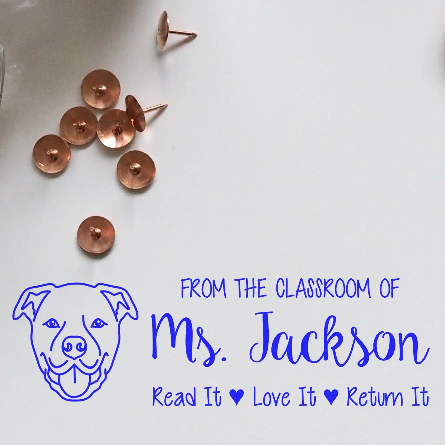 Personalized classroom rubber stamp with dog logo and Read It Love It Return It text for Ms. Jacksons teacher books.