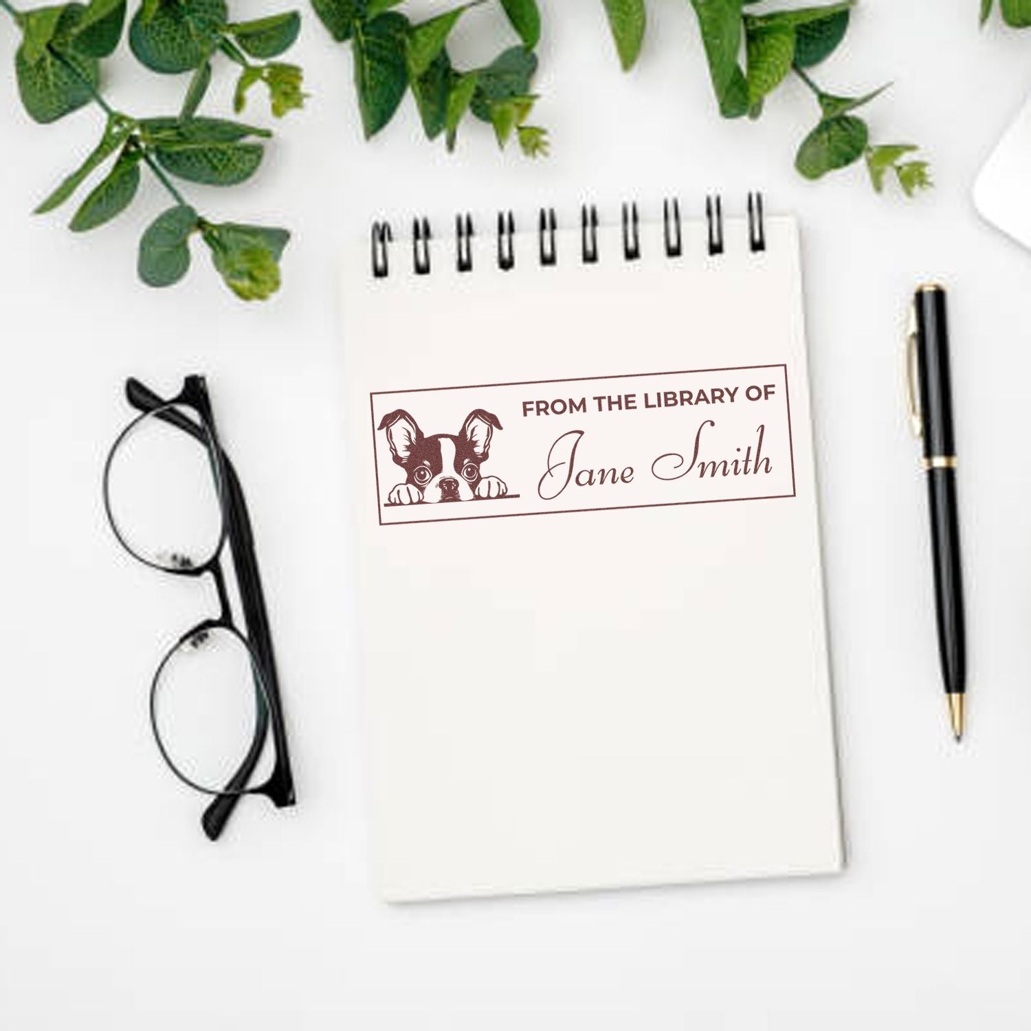 Personalized From the Library Of rubber stamp with dog design and Jane Smith name, shown on a notebook for book lovers.