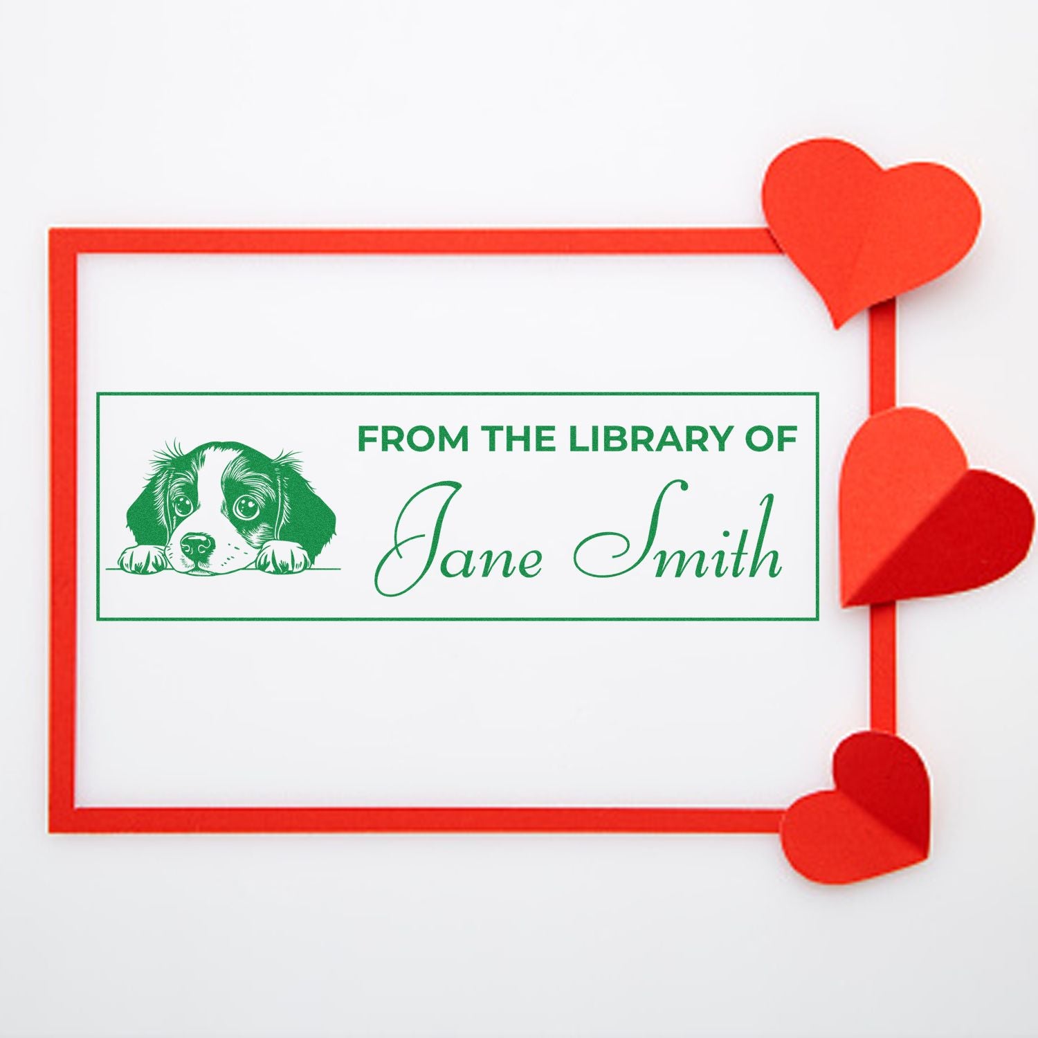 Custom library rubber stamp with puppy graphic and personalized From the Library of Jane Smith text, framed by red hearts.