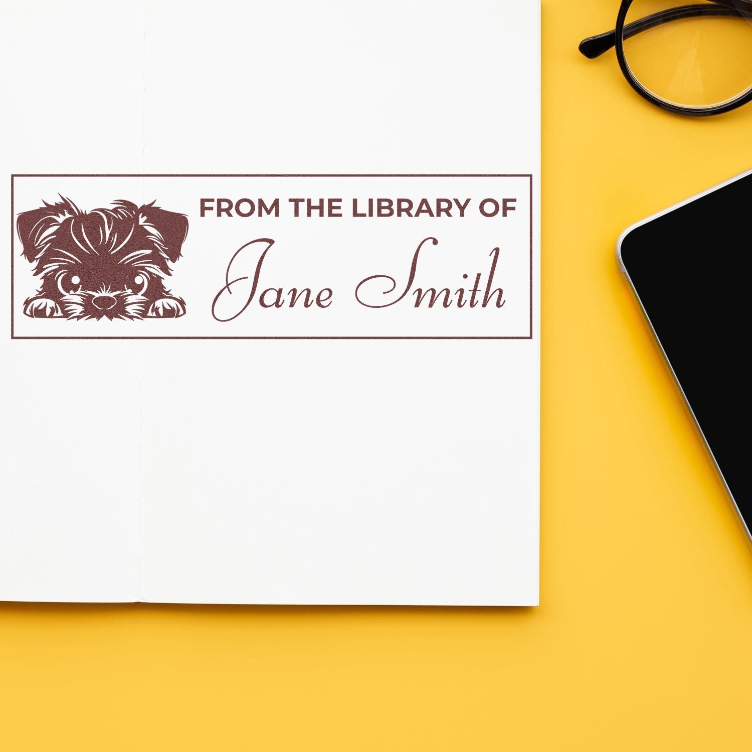 Personalized library rubber stamp with dog illustration and From the Library of Jane Smith on an open book.