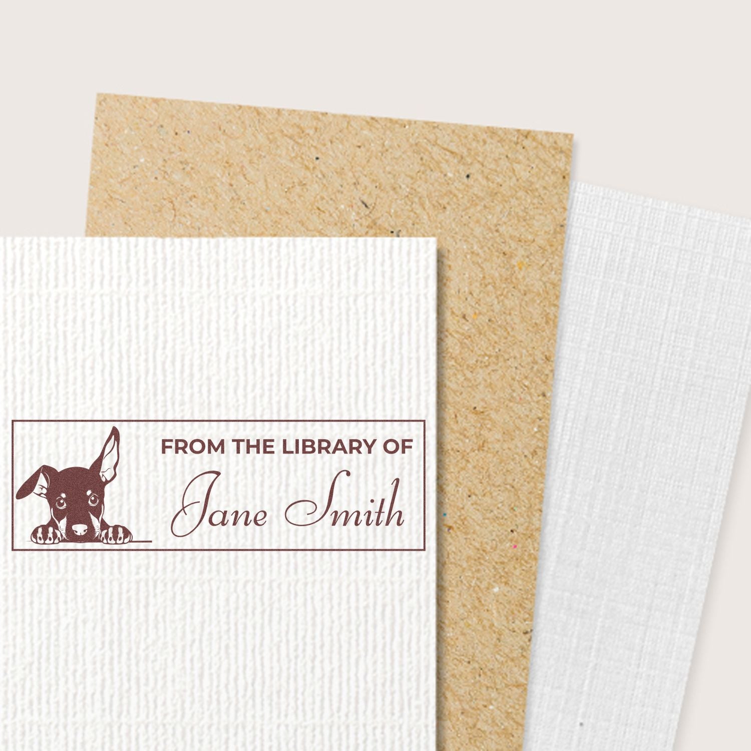 Custom rubber book stamp with dog illustration and From the Library of Jane Smith on textured paper.