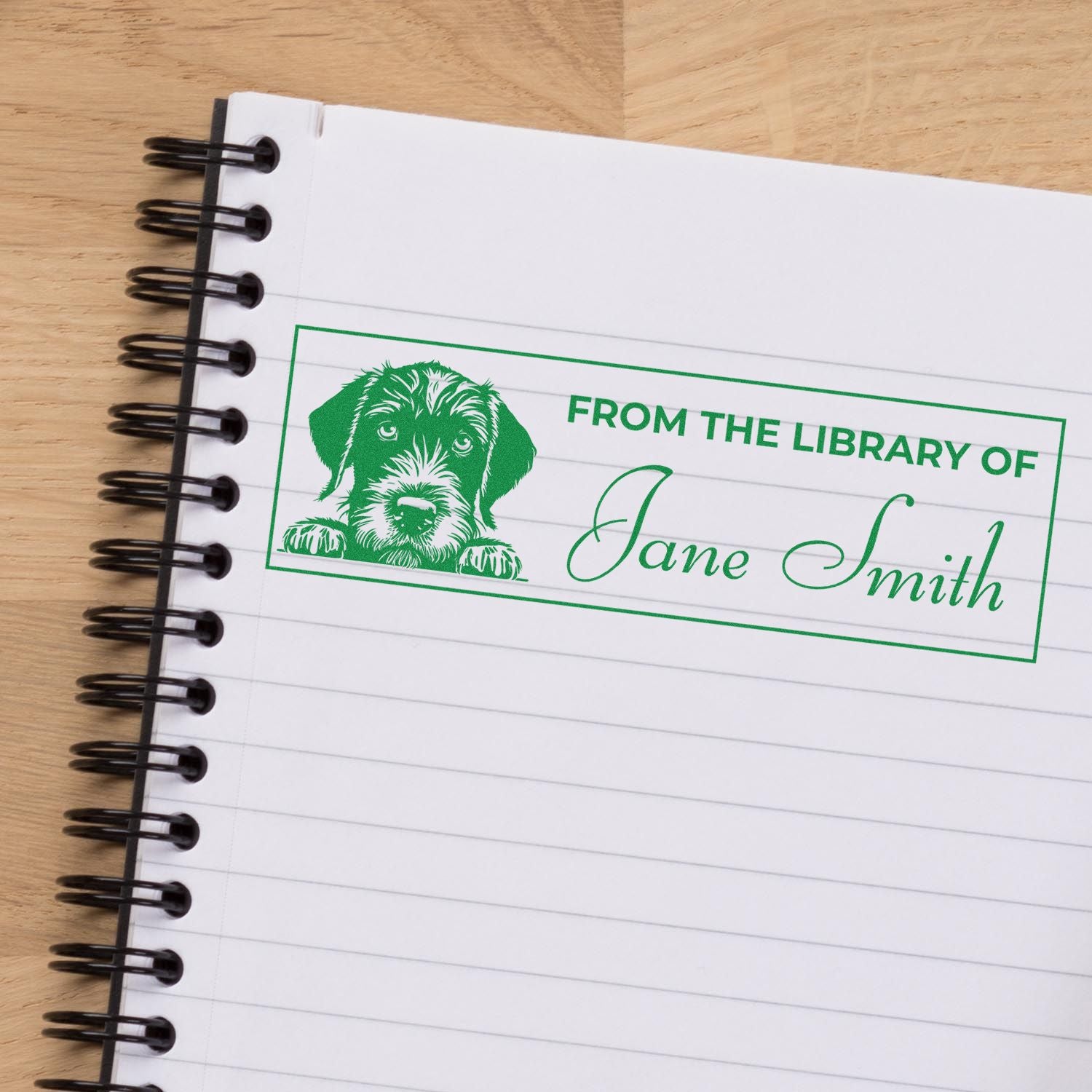Personalized dog-themed library rubber stamp reading From the Library of Jane Smith on a notebook page.